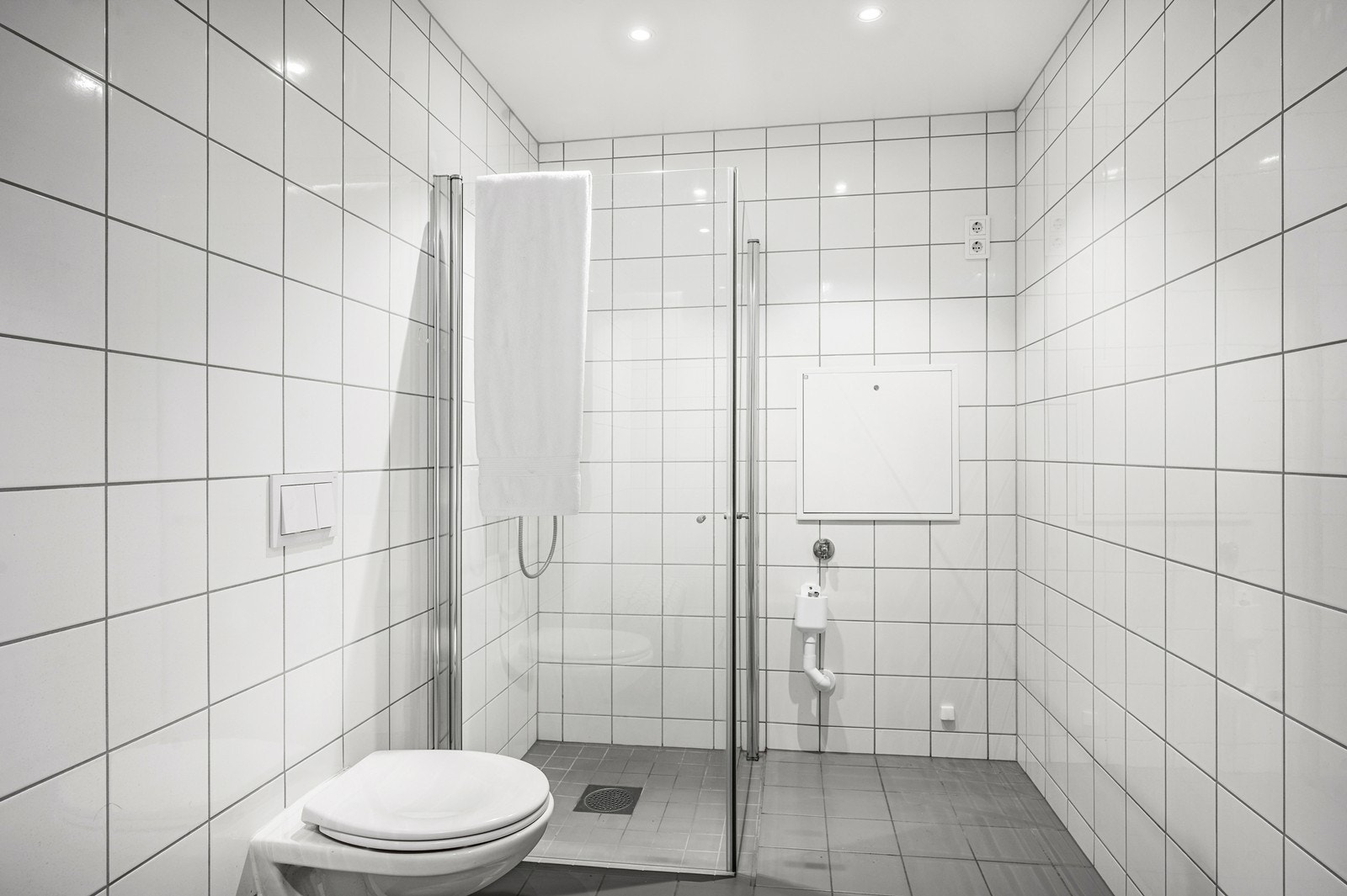 Badet har fliser på vegger og gulv. Det er opplegg til vaskemaskin på badet Galleribilde