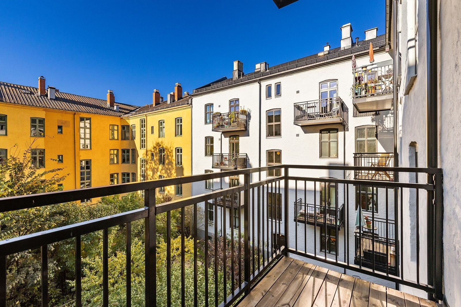 Solrik balkong vendt mot rolig, skjermet bakgård Galleribilde