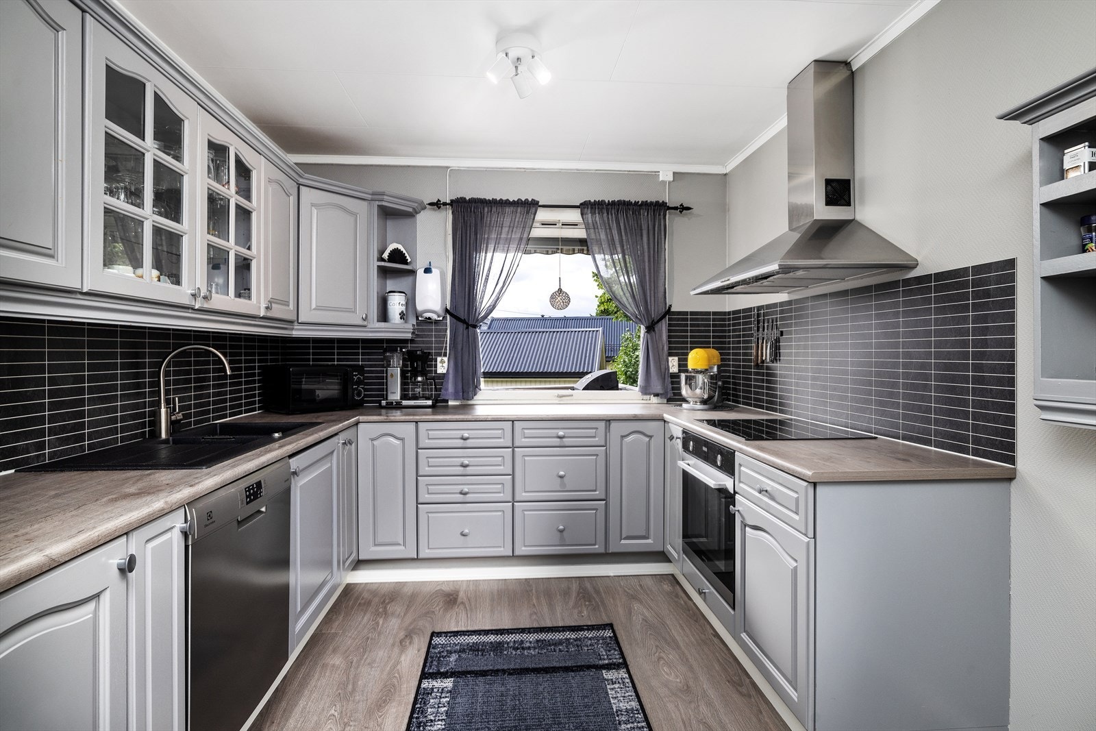 Kjøkkenet inneholder integrerte hvitevarer som komfyr, induksjon platetopp og oppvaskmaskin. Frittstående kjøleskap. Galleribilde