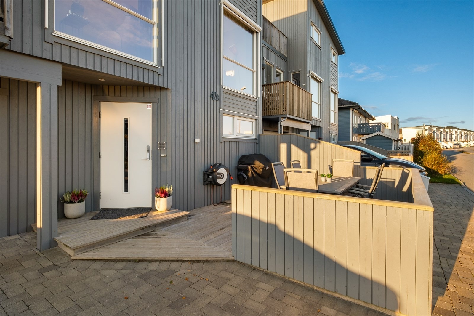 Pent inngangsparti, dels brosteinsbelagt innkjørsel og skjermet terrasse mot sør Galleribilde