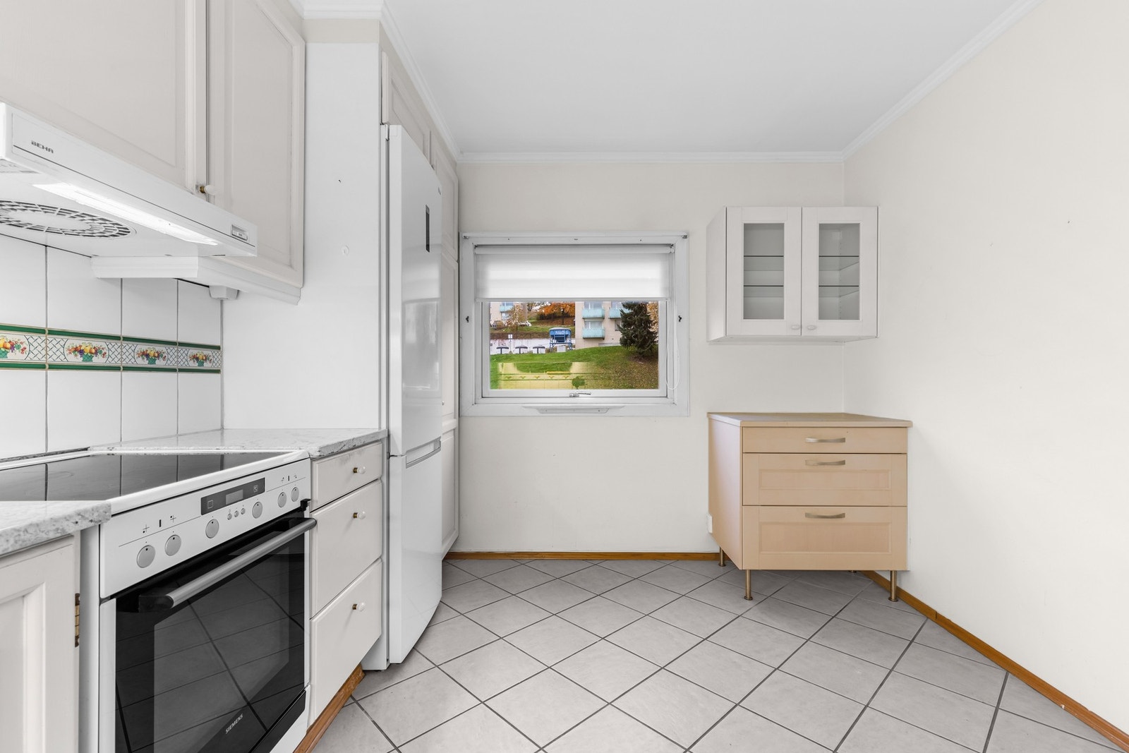 Et stort vindu gir rikelig med lysinnslipp og sørger for god atsmosfære under matlagingen. Benkeplate i stein. Galleribilde