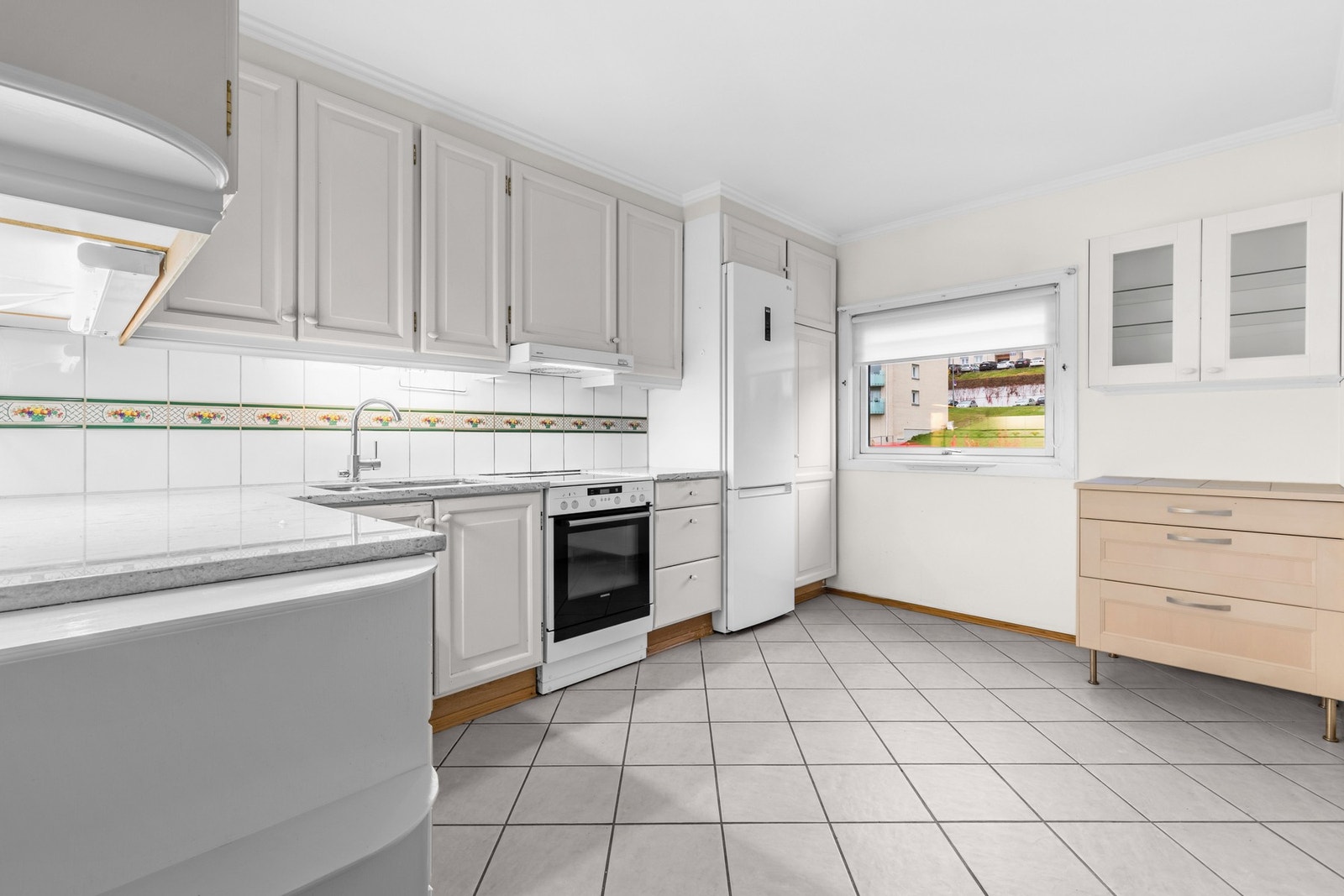 Kjøkkenet ligger adskilt fra stuen og er av romslig størrelse. Praktisk designet med mye benke- og skapplass samt muligheter for eget spisebord. Galleribilde