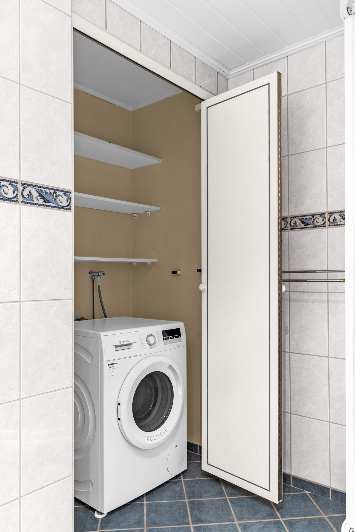 Praktisk nisjé med hylleløsning og plass til vaskemaskin. Galleribilde