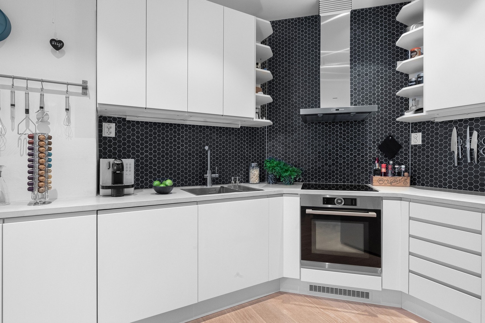 Innredningen består av glatte, hvite fronter som gir et rent og tidløst uttrykk, og under overskapene er det montert belysning. Galleribilde