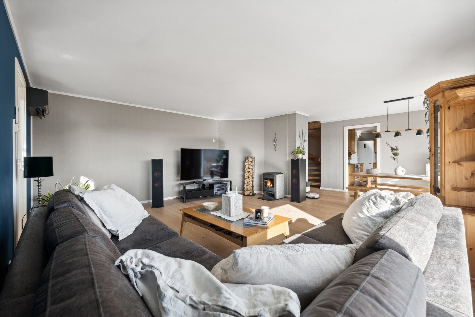 Stilfull stue med romslig sofa, peis og åpen planløsning, ideell for hyggelige sosiale sammenkomster. Galleribilde