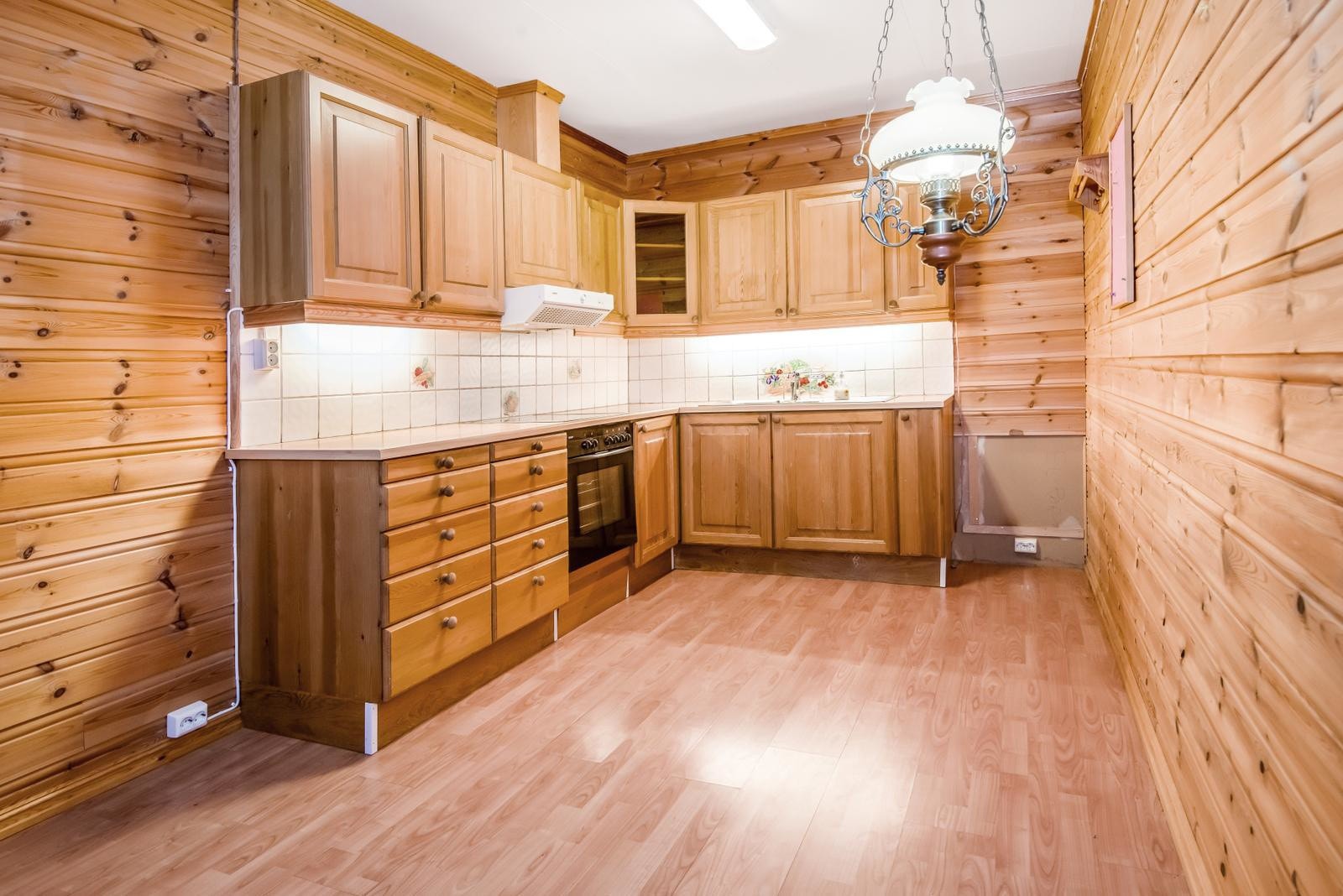 Tradisjonelt kjøkken i hybelen med heltre innredning og god benkeplass, perfekt for funksjonell matlaging i et koselig miljø. Galleribilde