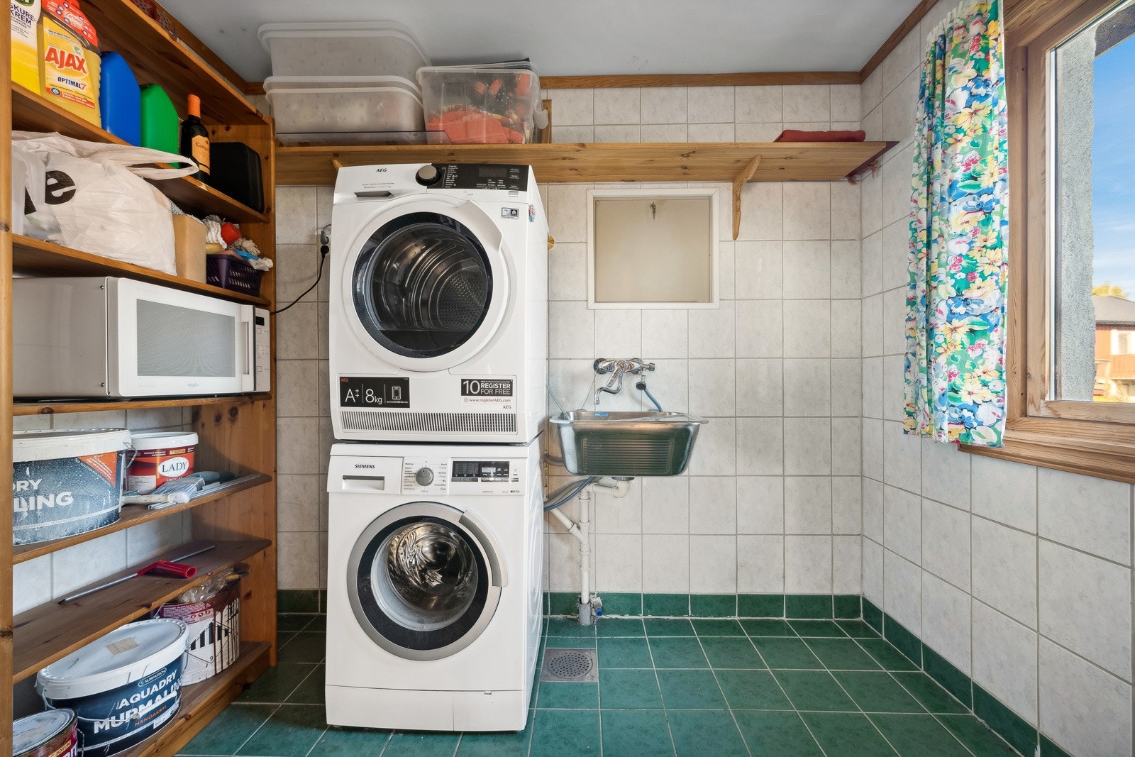 Vaskerom fra byggeår. Flislagt gulv med gulvvarme og flislagte vegger. Naturlig sollys slippes inn gjennom vinduet. Galleribilde