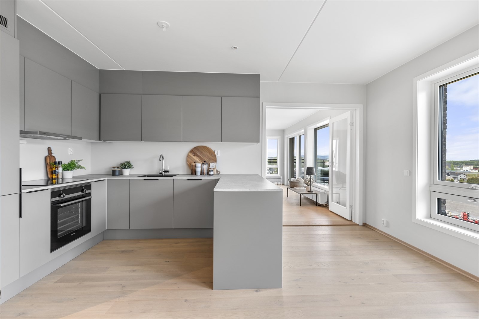 Kjøkkenet har et moderne, tidløst og stilfullt U-formet design med mye oppbevaringsplass og godt med benkeplass. Galleribilde