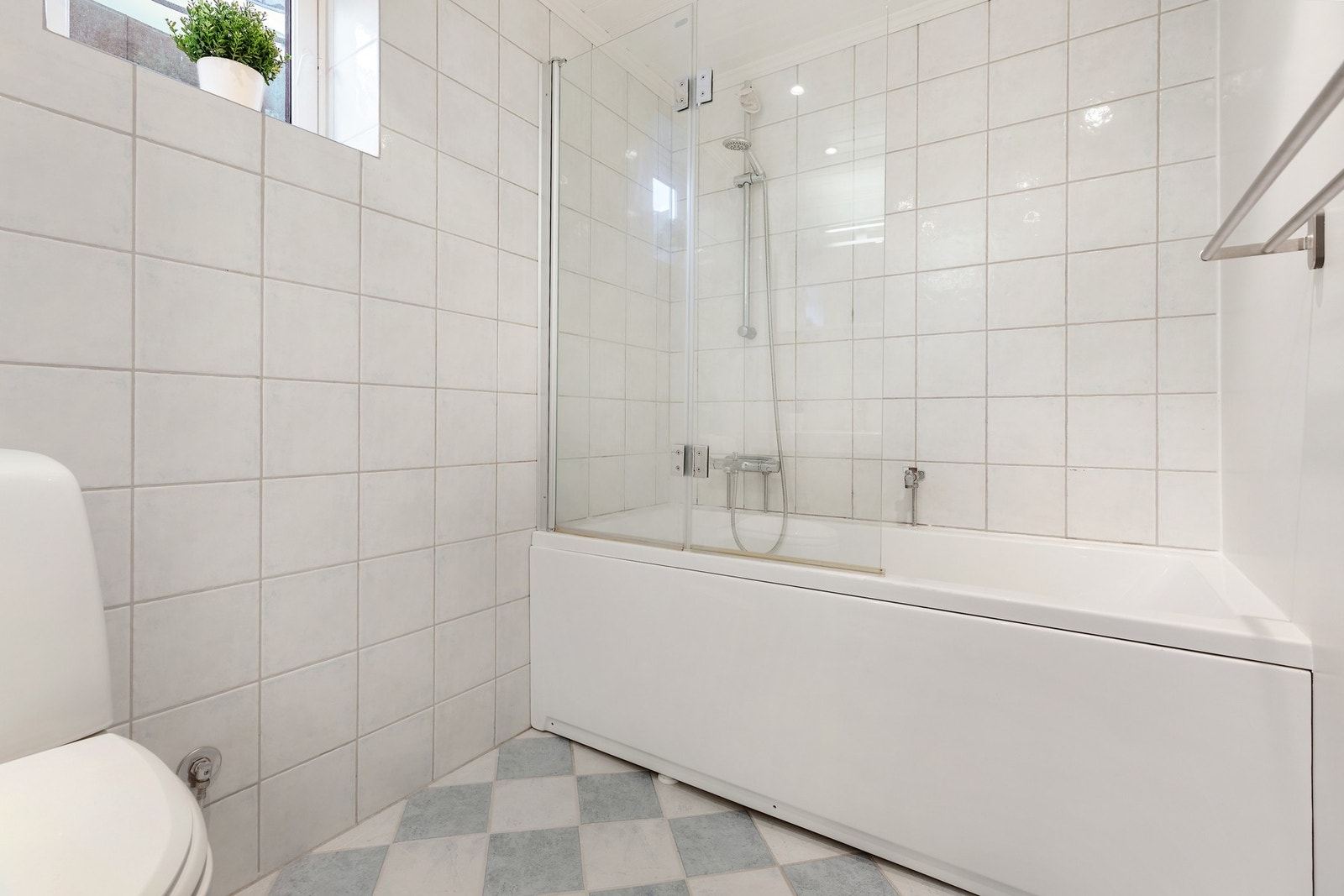 Lyst og flislagt bad med badekar og gulvvarme. Galleribilde