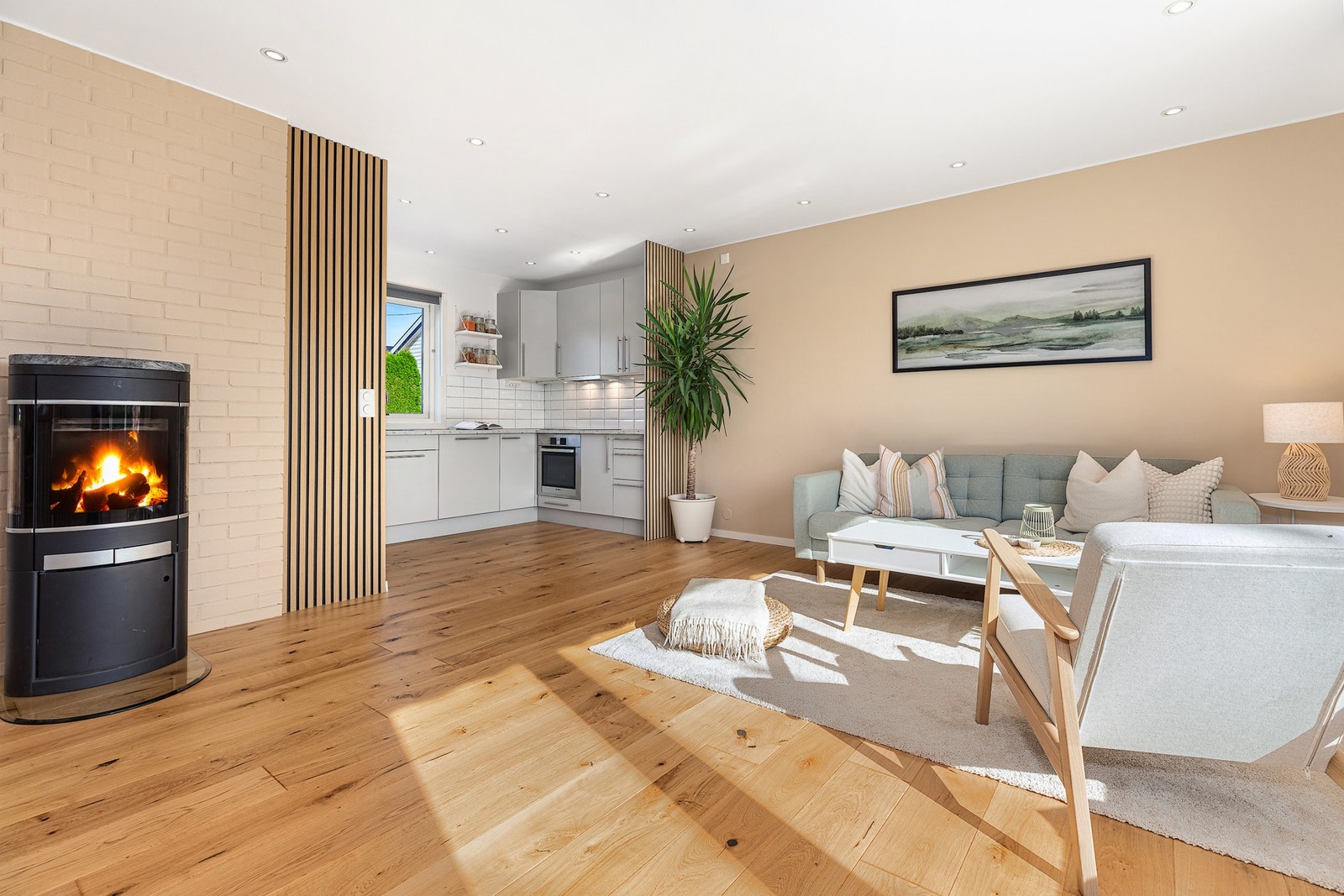 Lys og innbydende stue med en åpen kjøkkenløsning i eget avlukke. Galleribilde