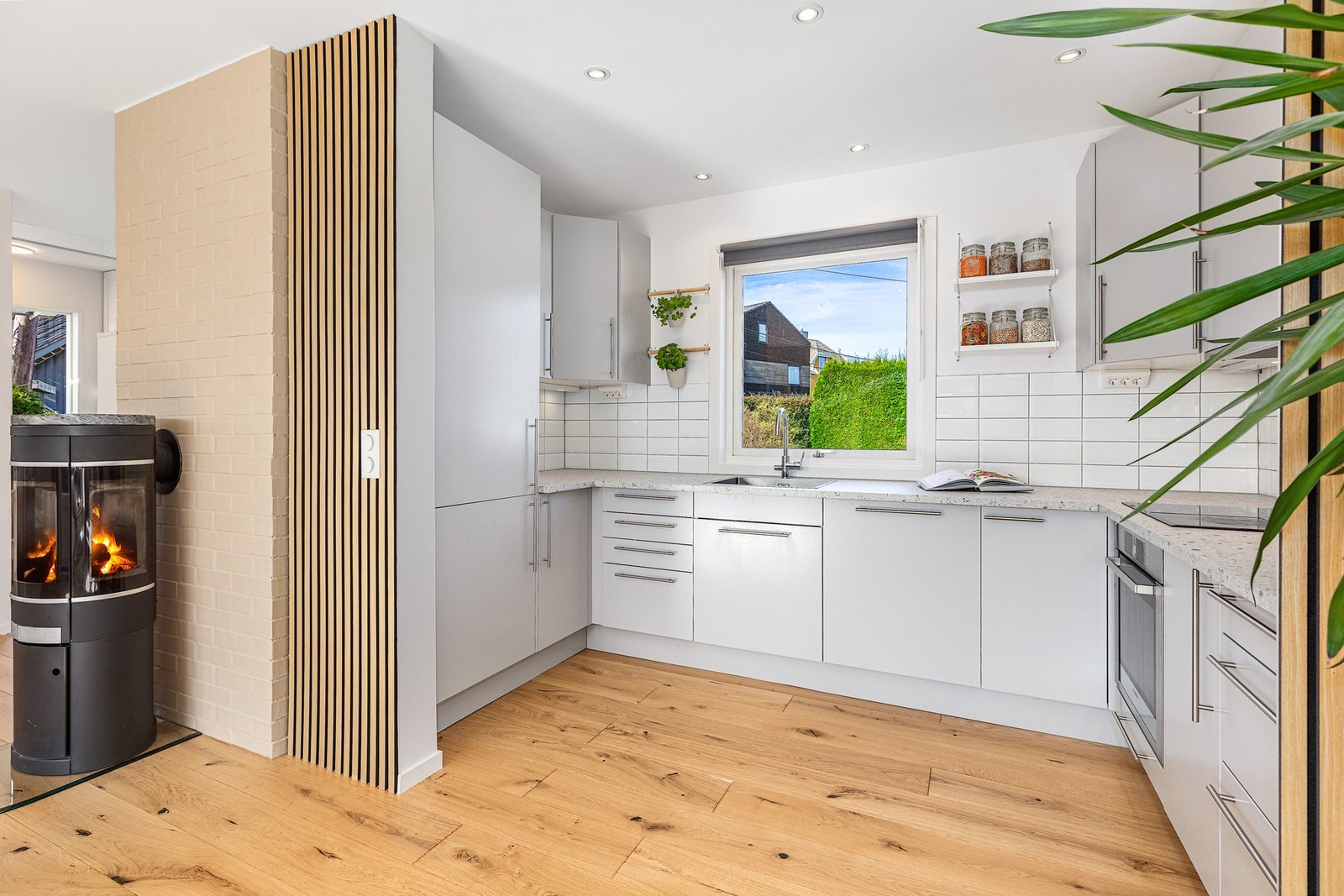 Pent og moderne kjøkken med stort vindu som gir gjennomlys. Galleribilde