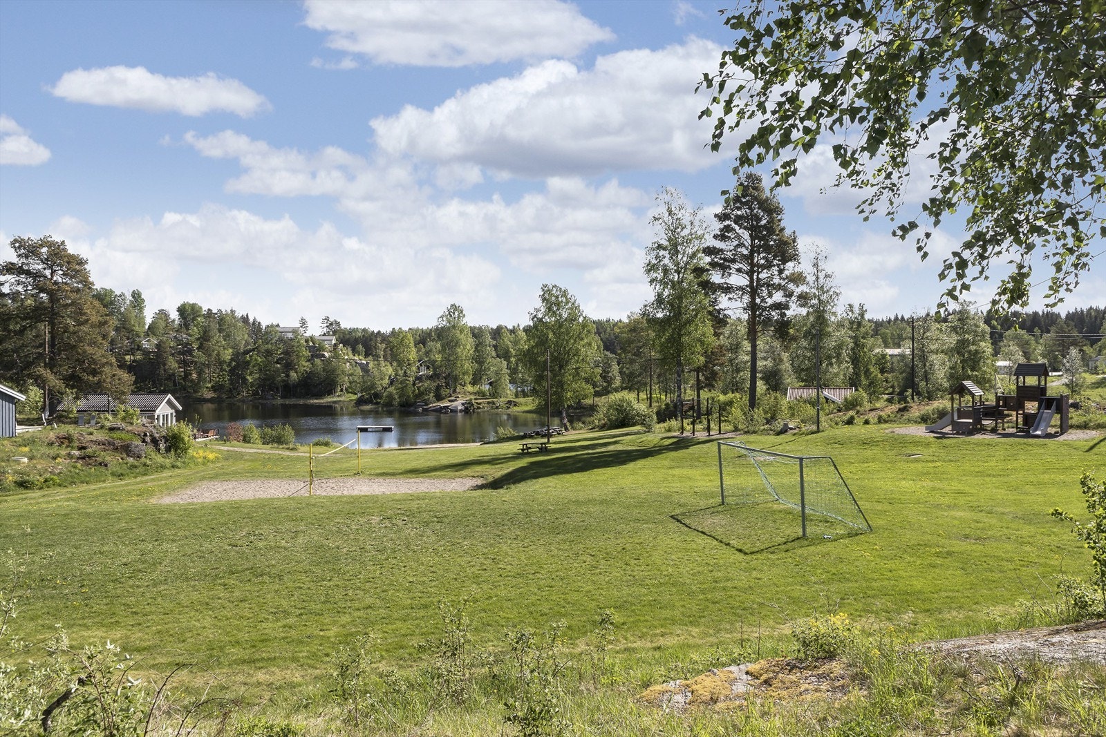 Fellesarealene består av grøntområder, lekeapparater, volleyballbane, badestrand og badebrygger Galleribilde