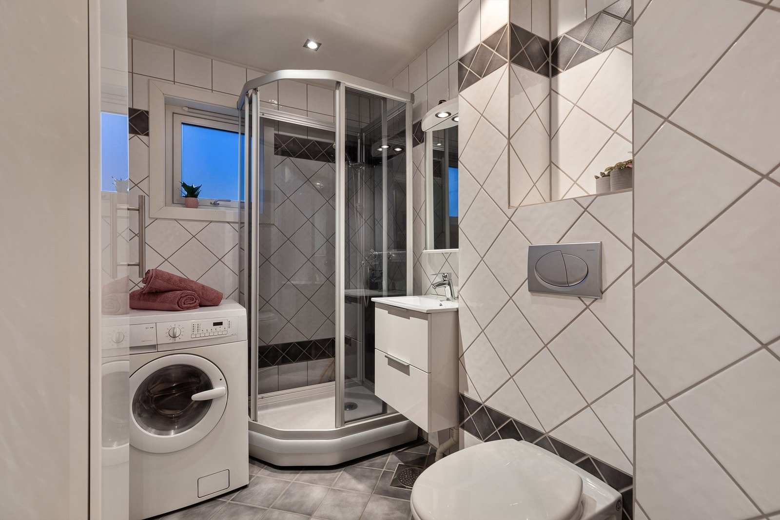 Bad med varmekabler i gulv og opplegg til vaskemaskin Galleribilde