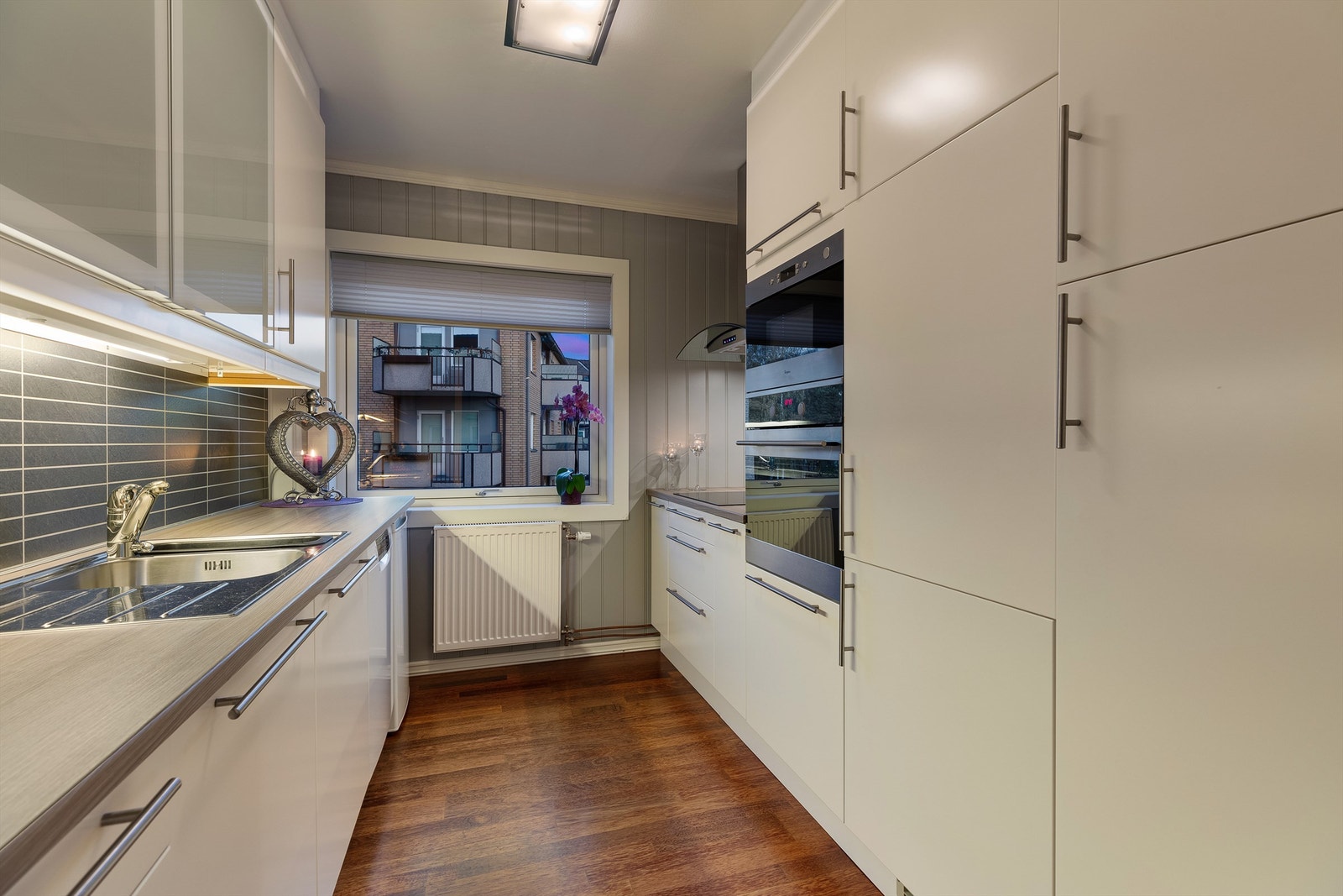 Lekkert kjøkken med glatte fronter og integrerte hvitevarer Galleribilde