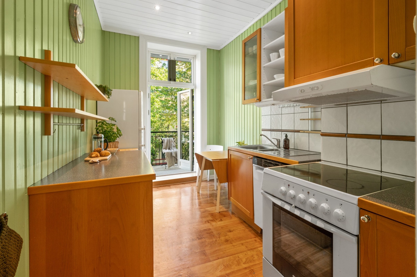 Sjarmerende, separat kjøkken. Innredning i glatte fronter og benkeplate av laminat. Flislagt flate mellom benkeplaten og overskap. Galleribilde