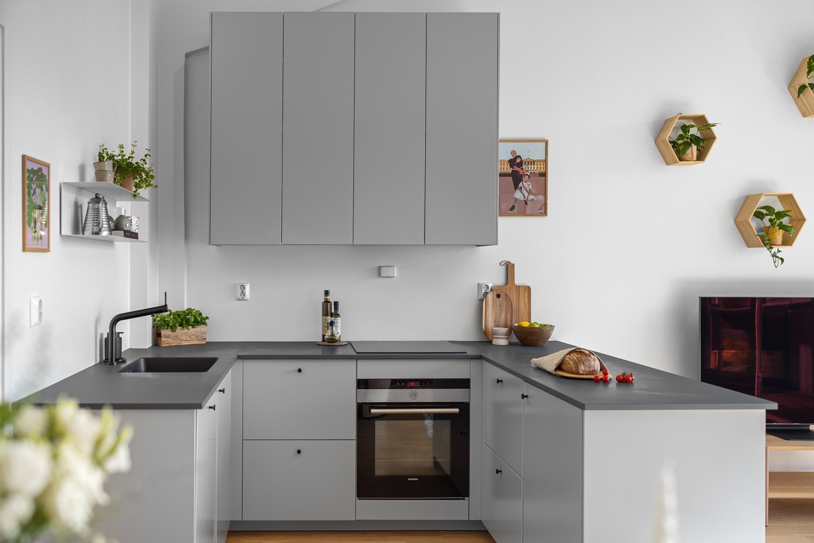 Moderne kjøkkeninnredning med lyse glatte fronter. Benkeplaten er av laminat med planlimt oppvaskkum i kompositt. Galleribilde