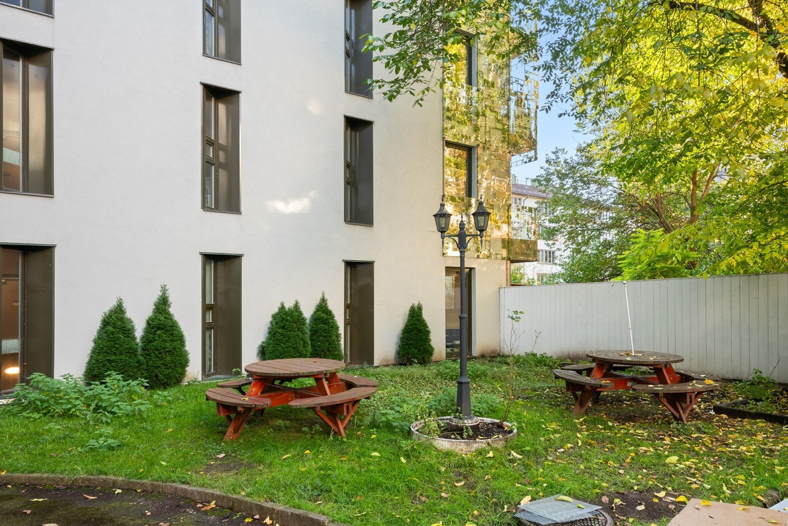 Bakgård er pent opparbeidet med gressplen, trær, sittegrupper, prydbusker og diverse beplantning. Galleribilde