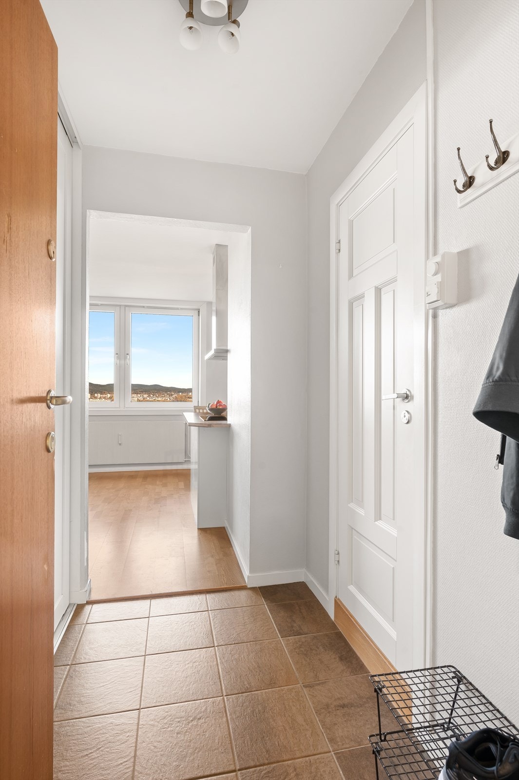 Man ønskes velkommen i en lys entré med plass til å henge fra seg ytterklær og sko. Galleribilde