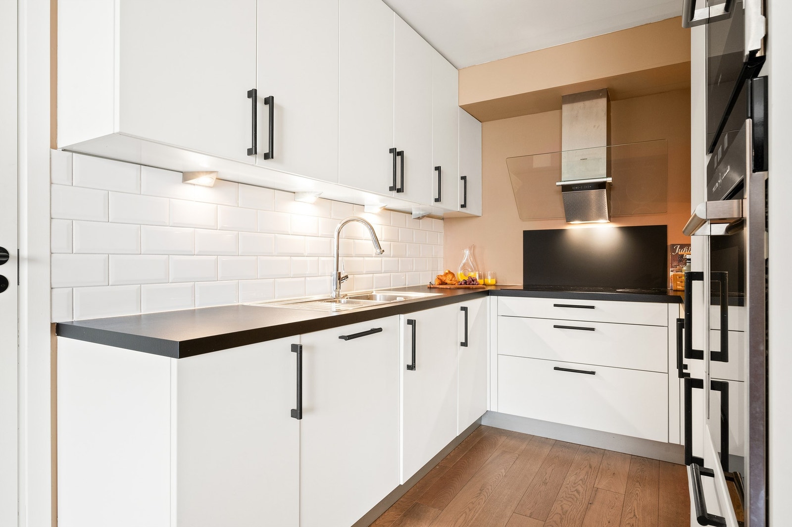 Kjøkkeninnredningen med glatte fronter og benkeplate i laminat med nedfelt vask- og skyllekum. Galleribilde