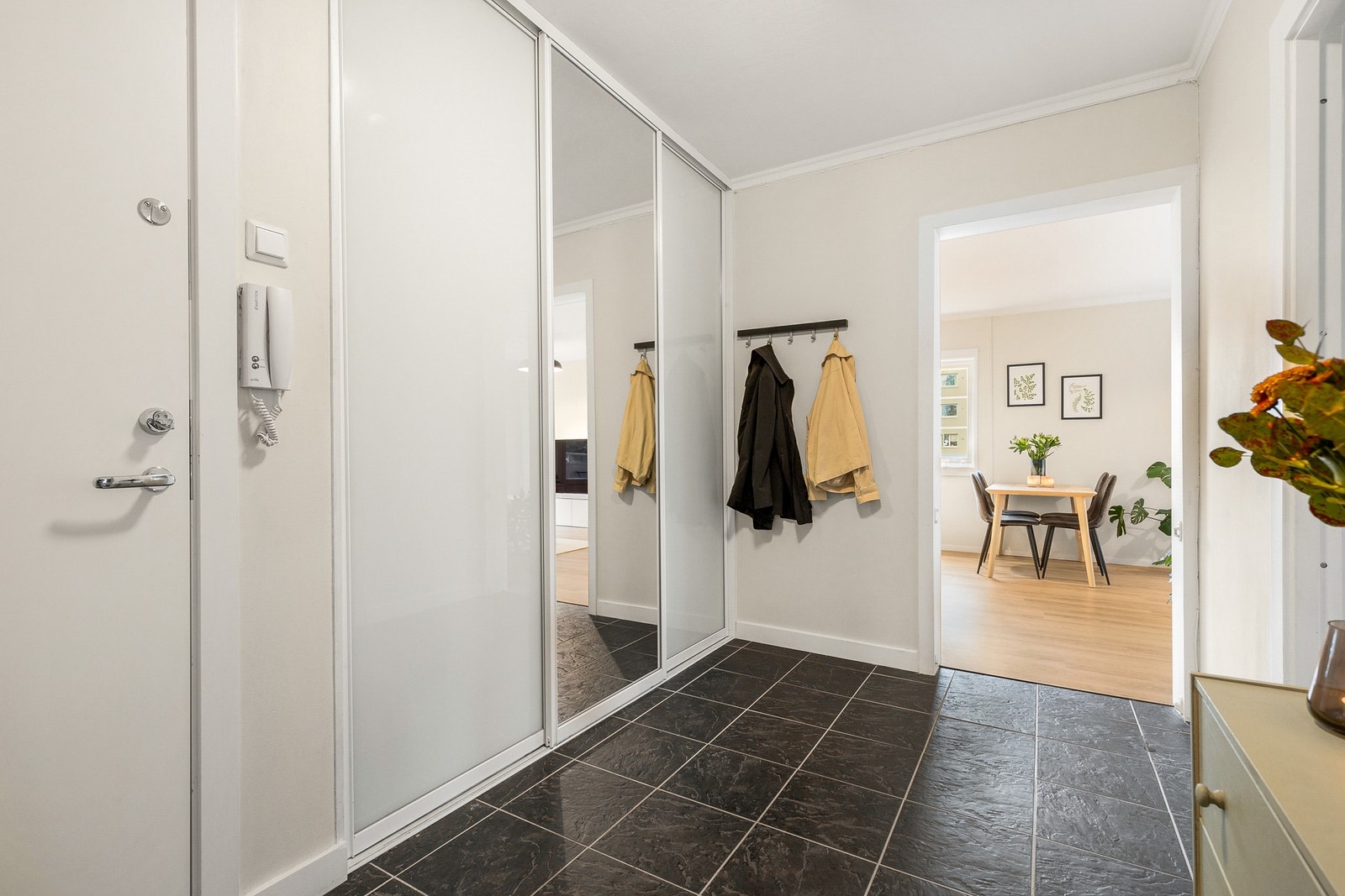 Entrè med fliser og skyvedørsgarderobe med delvis speilfront Galleribilde