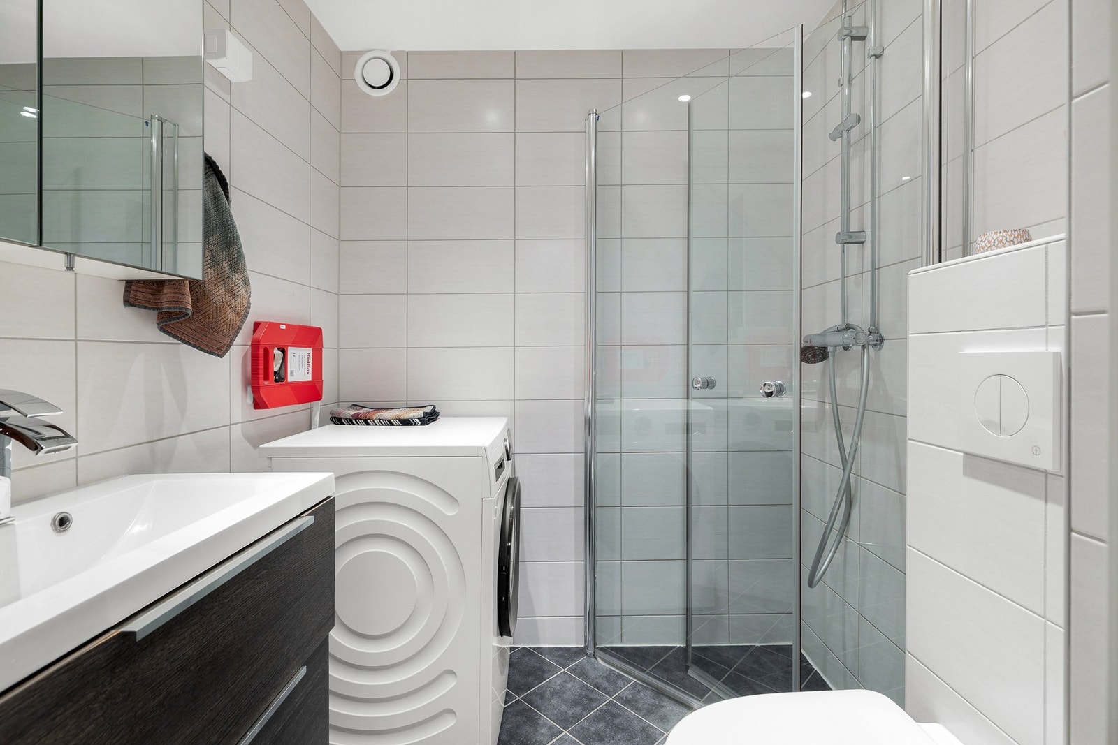 Flislagt bad med dusjhjørne og opplegg for vaskemaskin Galleribilde