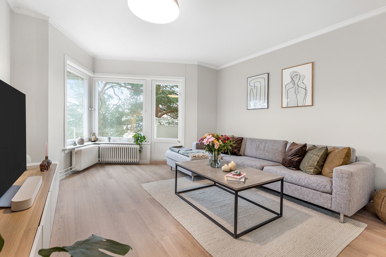 Hyggelig stue med store vindusflater samt utgang til balkong Galleribilde