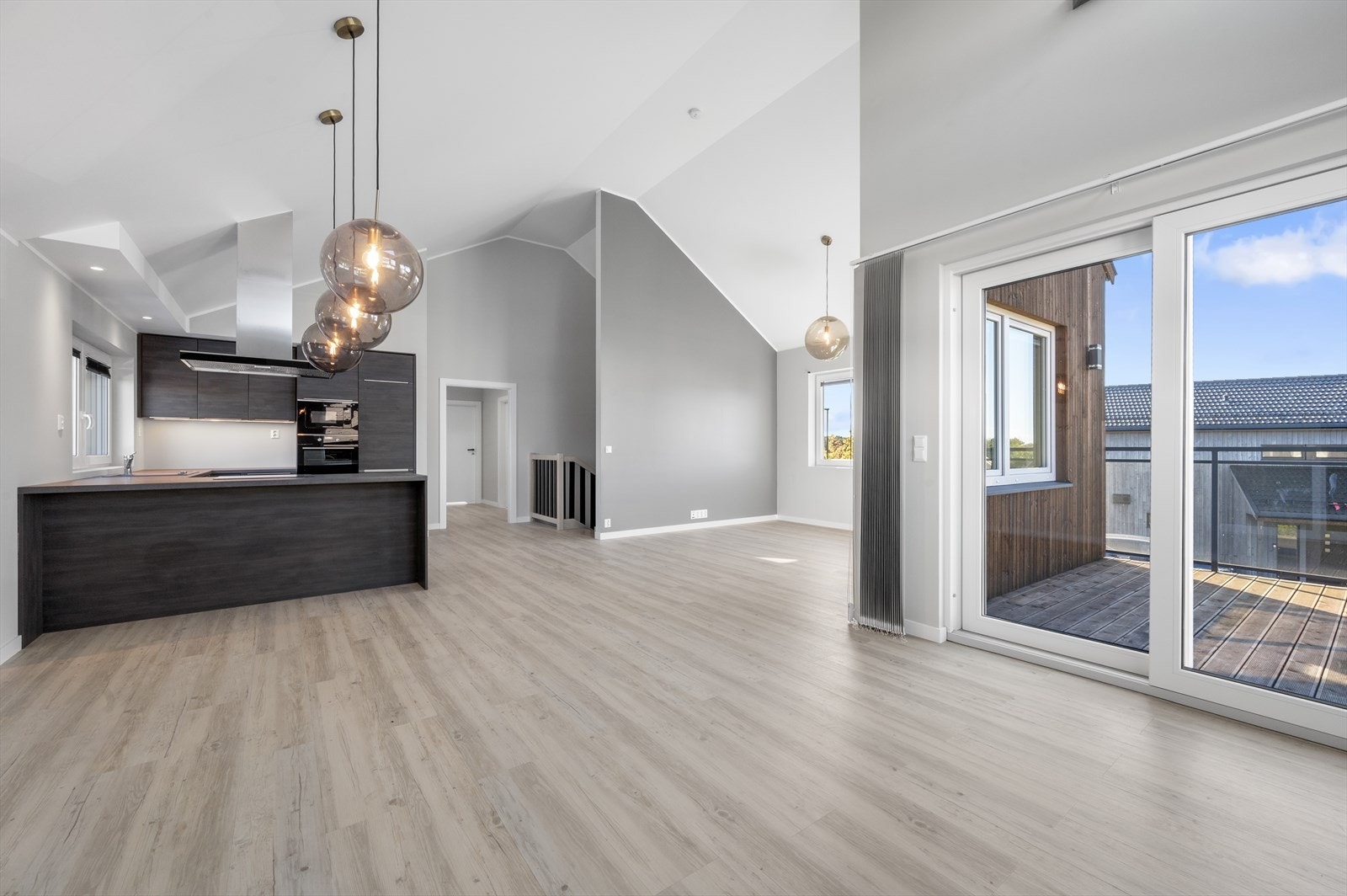 Kombinert kjøkken og stor stue med utgang til solrik veranda Galleribilde