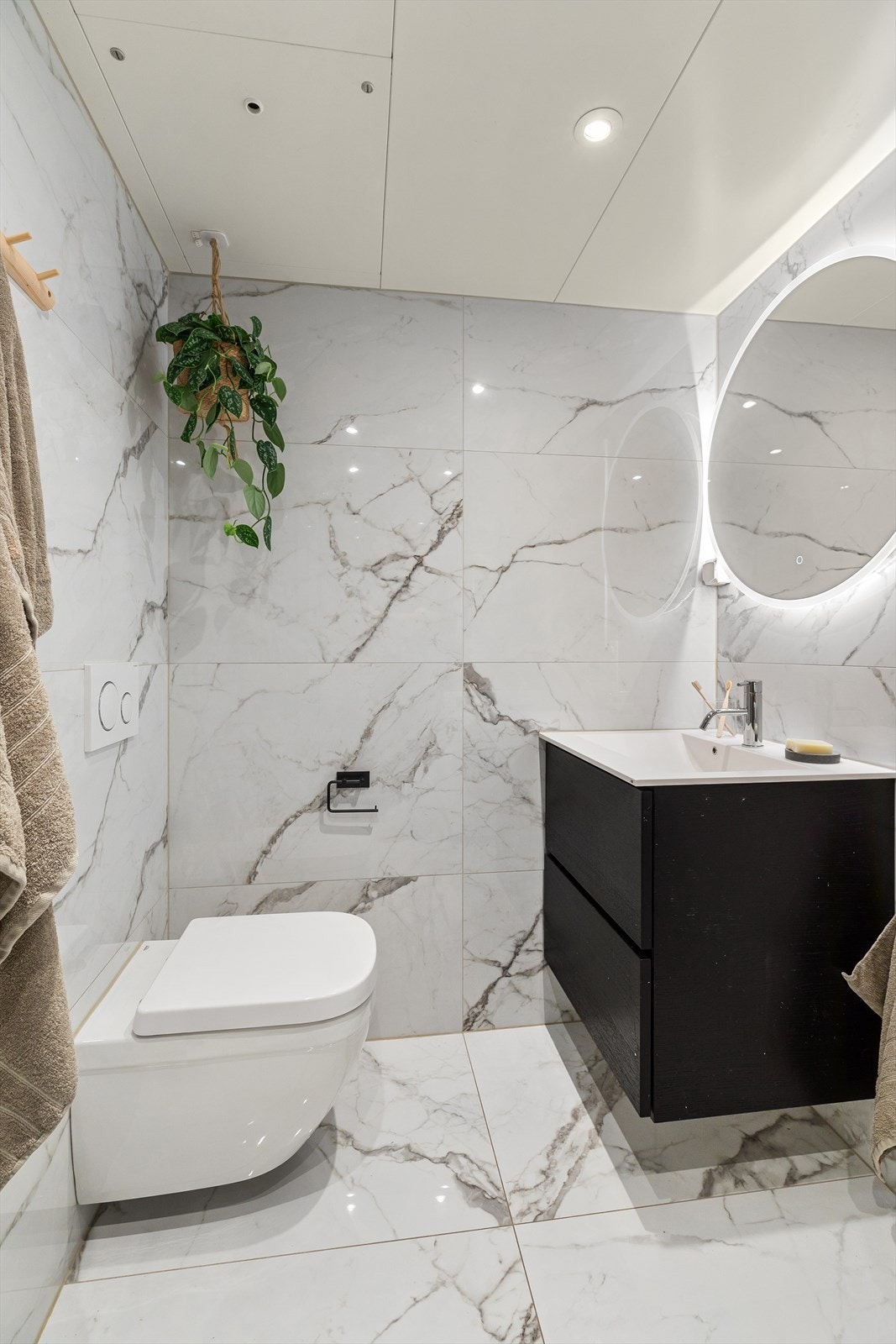 Det er utstyrt med innredning bestående av servantskap med nedfelt servant med underskuffer, dusjhjørne med glassdører, opplegg for vaskemaskin og vegghengt toalett. Galleribilde