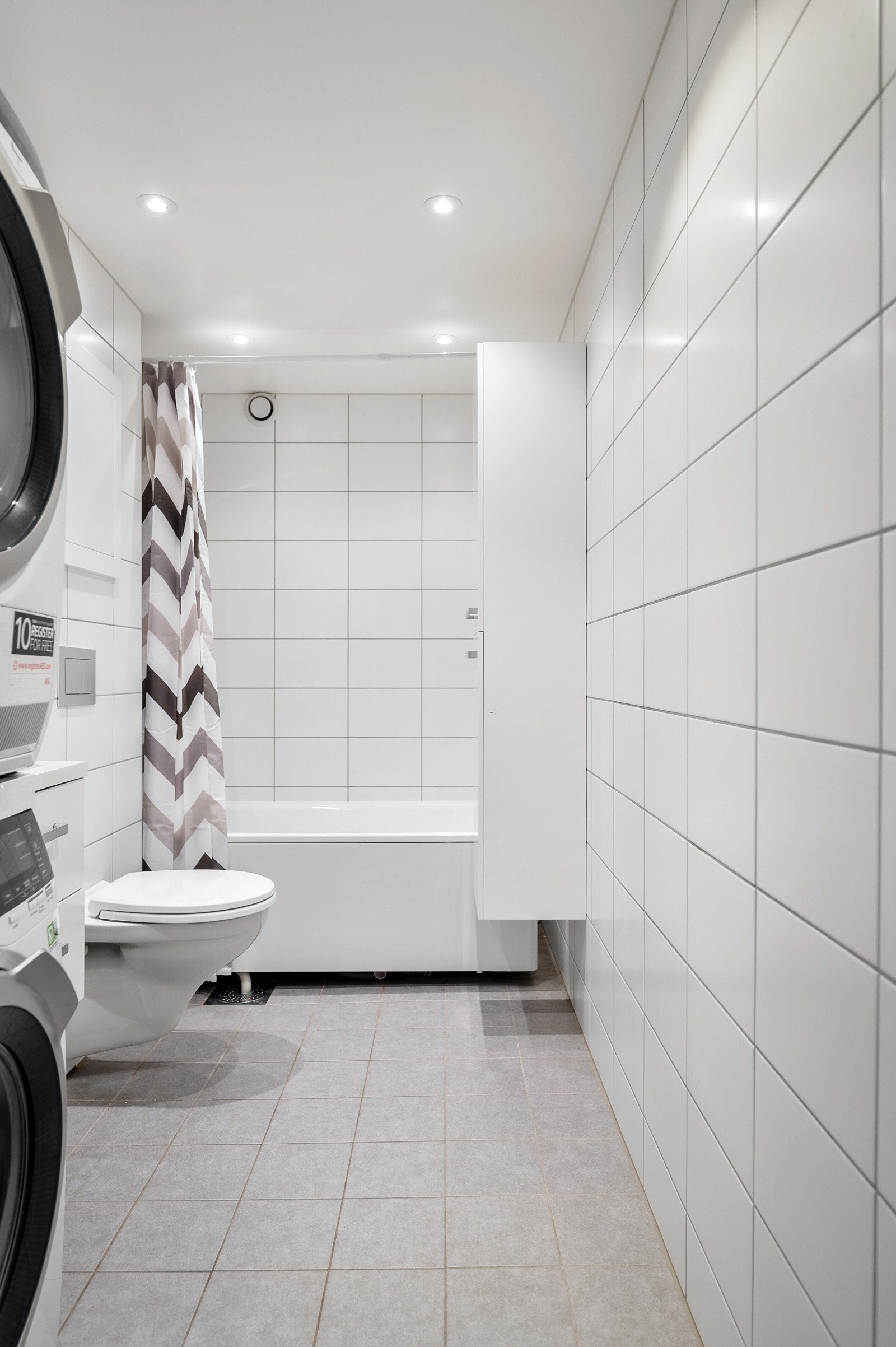 Baderommet er innredet med vegghengt servantskap, speilskap og høyskap. Videre har badet et frittstående badekar og et vegghengt toalett med innebygget sisterne. Galleribilde