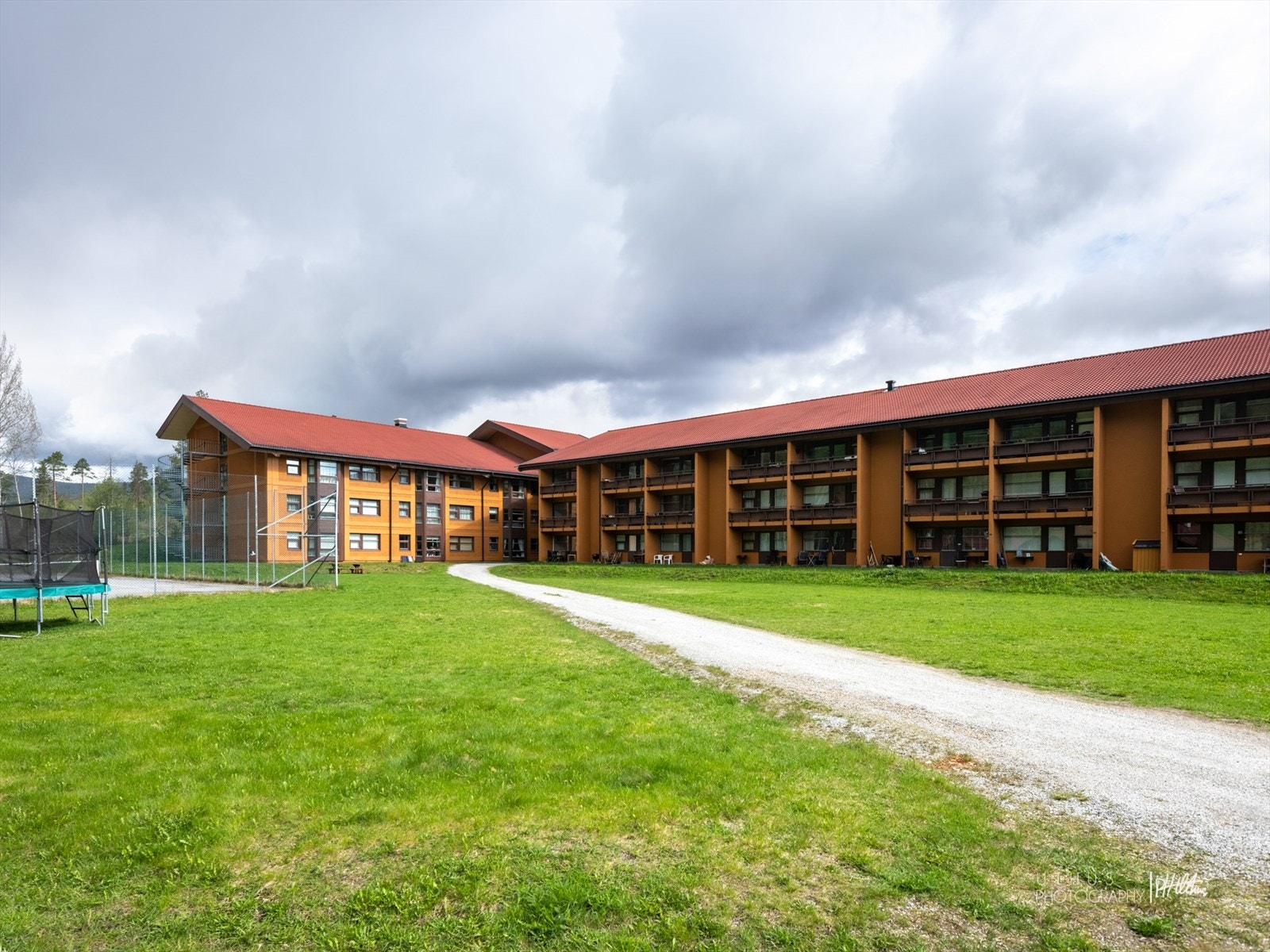 Eiendommen er pent opparbeidet med plen og noe beplantning. På hotellets fremside er det rikelig med parkeringsplasser Galleribilde