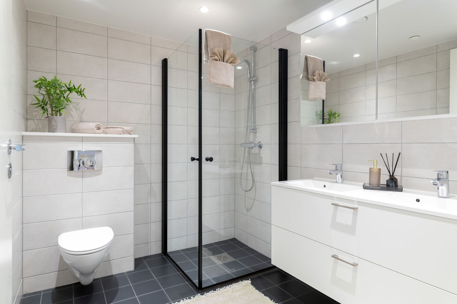 Det første badet er et moderne flislagt baderom med spotter i taket og varmekabler i gulvet. Galleribilde