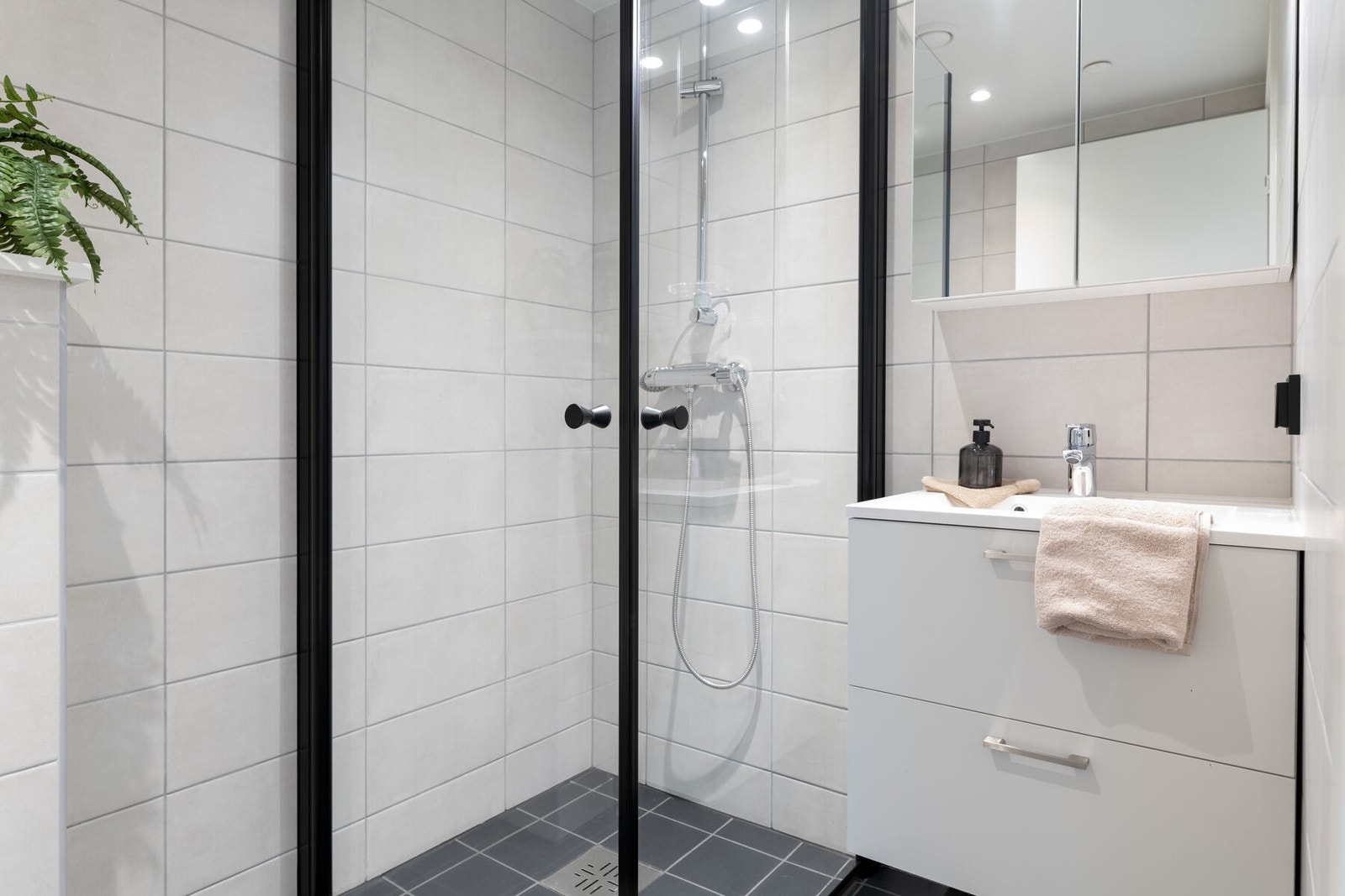 Det andre badet er også innredet med toalett, dusjhjørne og servant på innredning med speilskap. Galleribilde