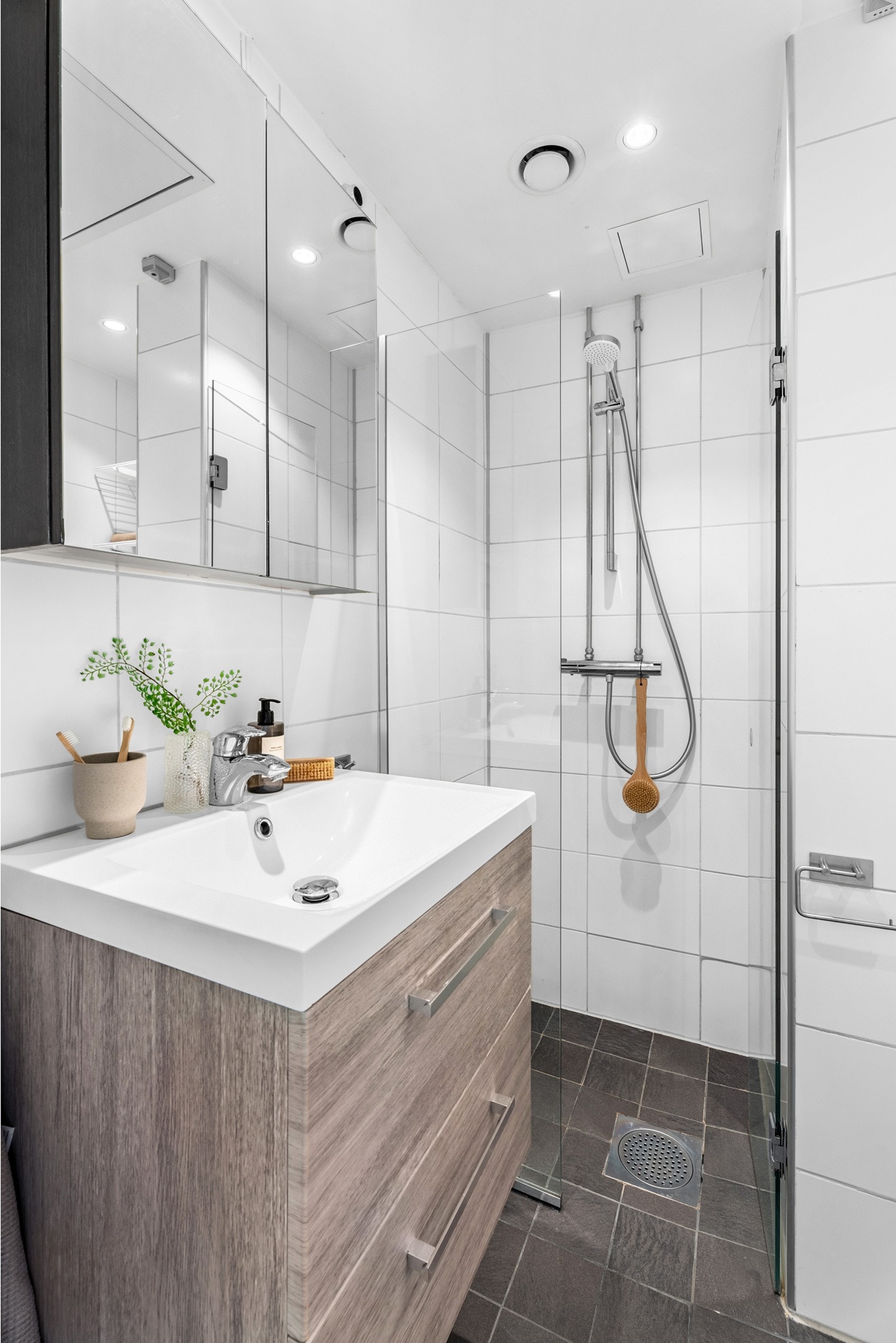 Gulvet er flislagt med termostatstyrte varmekabler som gir behagelig varme. Badet har en praktisk dusjsone med svingdører Galleribilde