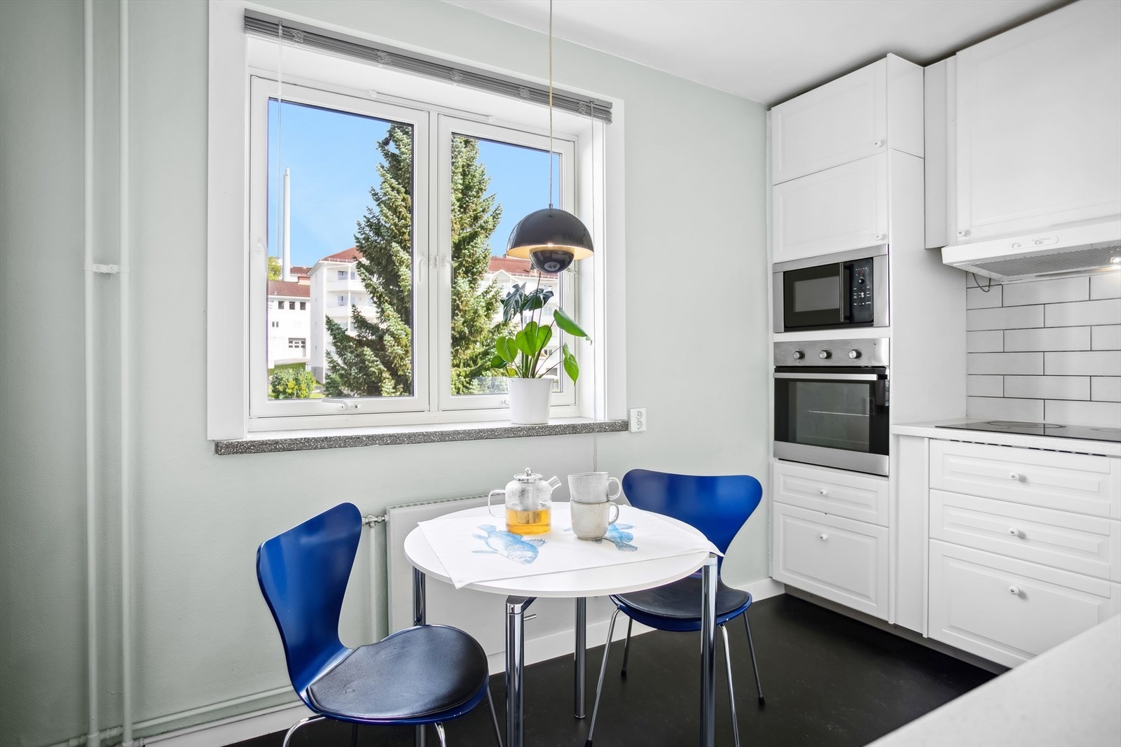 Kjøkkenet har innredning med lyse, profilerte fronter, laminat benkeplate og fliser over benk. Galleribilde