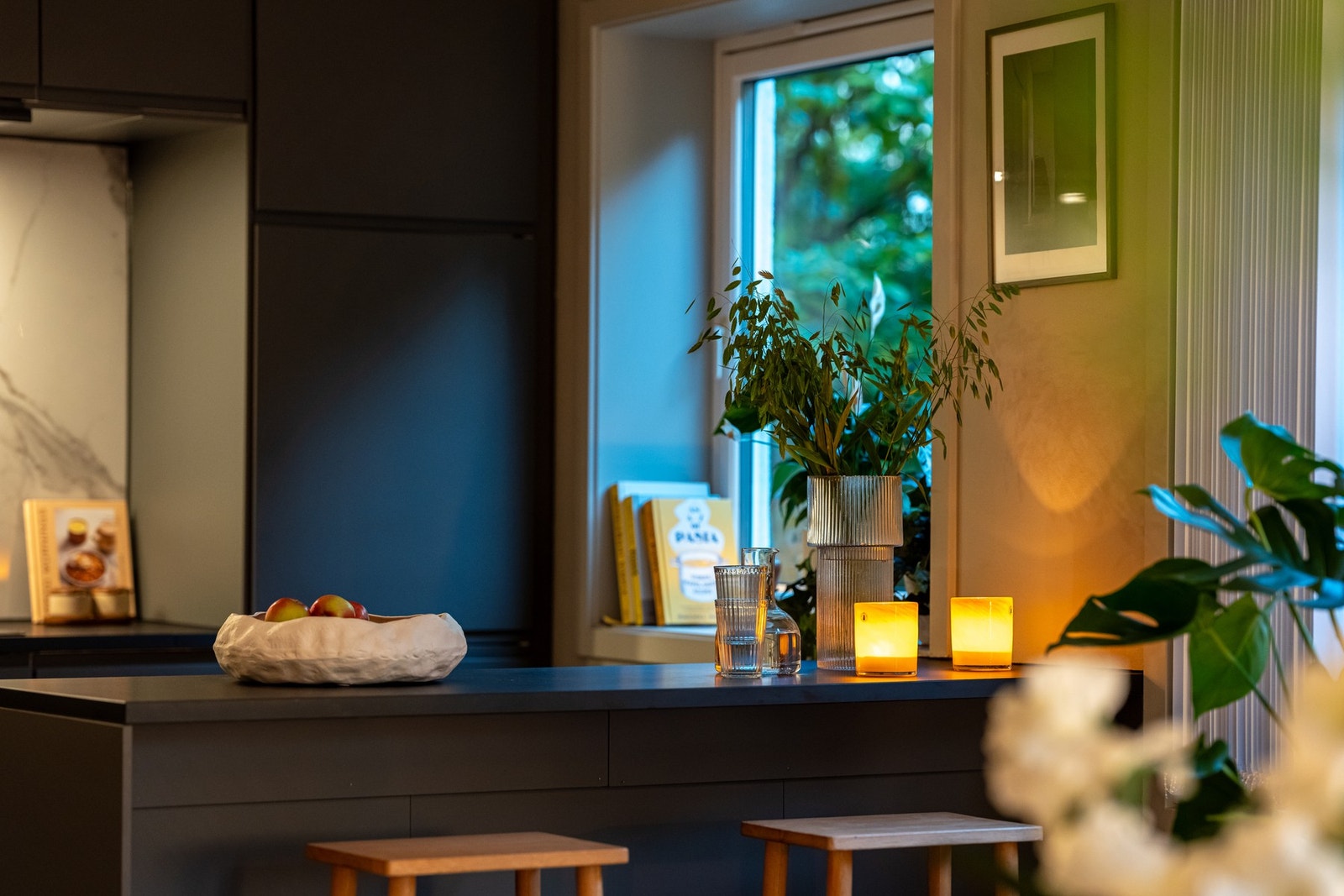 Det er en stilren kjøkkeninnredning fra IKEA med kjøkkenøy som skiller stue og kjøkken naturlig. Galleribilde