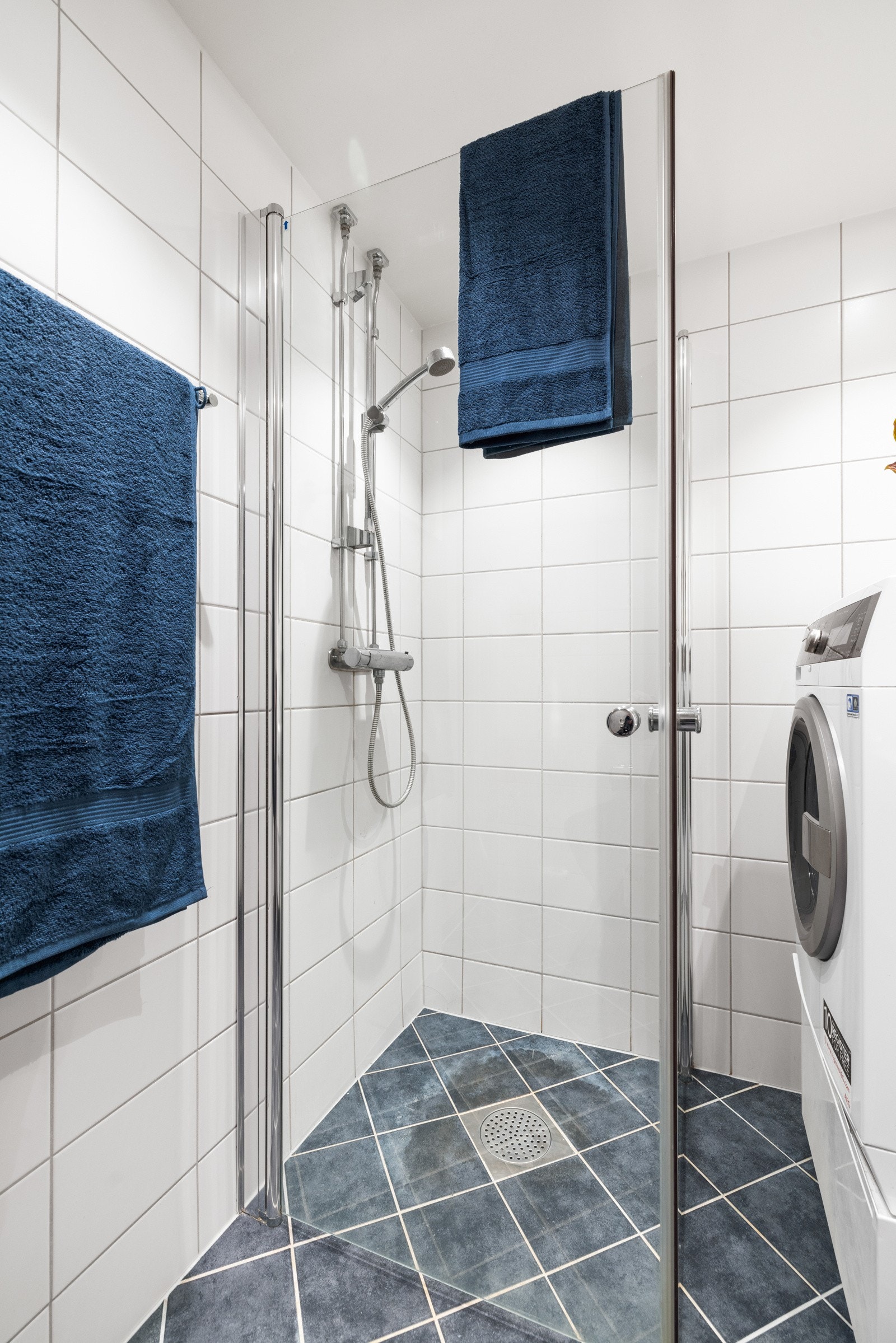 Her er det veggmontert toalett, dusjhjørne med innfellbare glassdører og opplegg for vaskemaskin Galleribilde