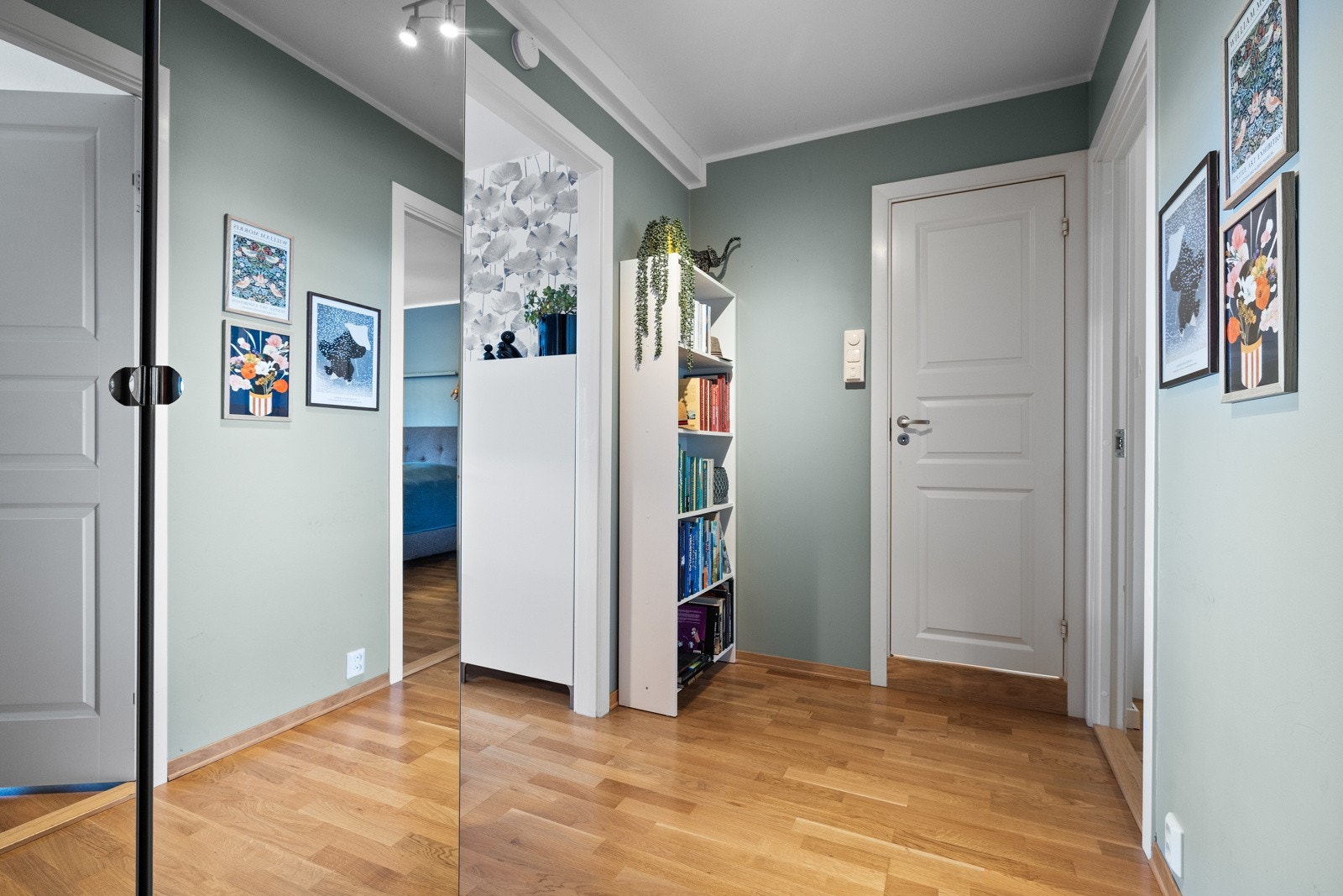 Entreen har parkettgulv, en kjølig mintfarge på veggene og god belysning fra spotter i himling Galleribilde