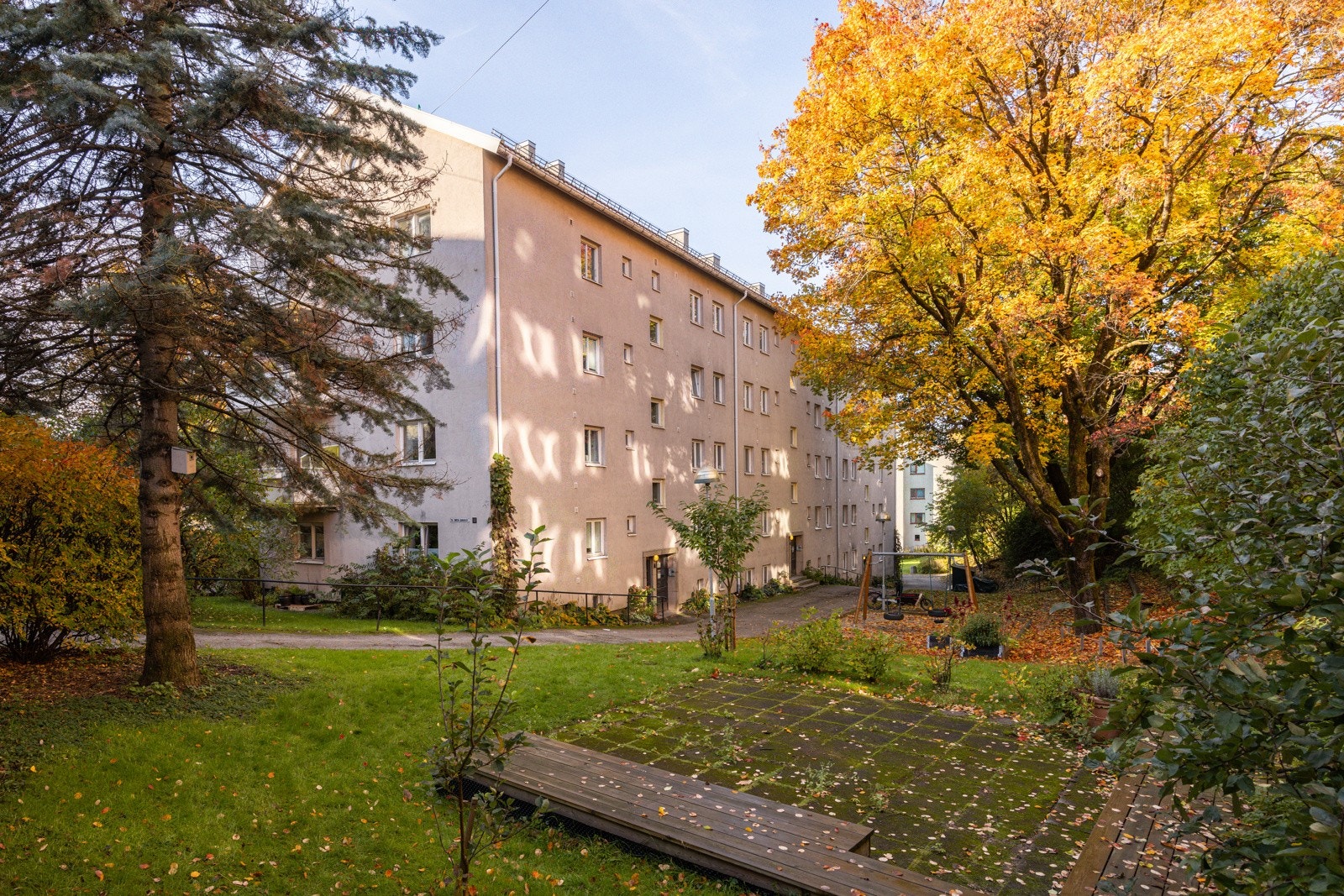 Felles tomt opparbeidet med blant annet asfalterte internveier, gressplen, trær, prydbusker og diverse beplantning. Lekeomeråde og sittegrupper. Galleribilde