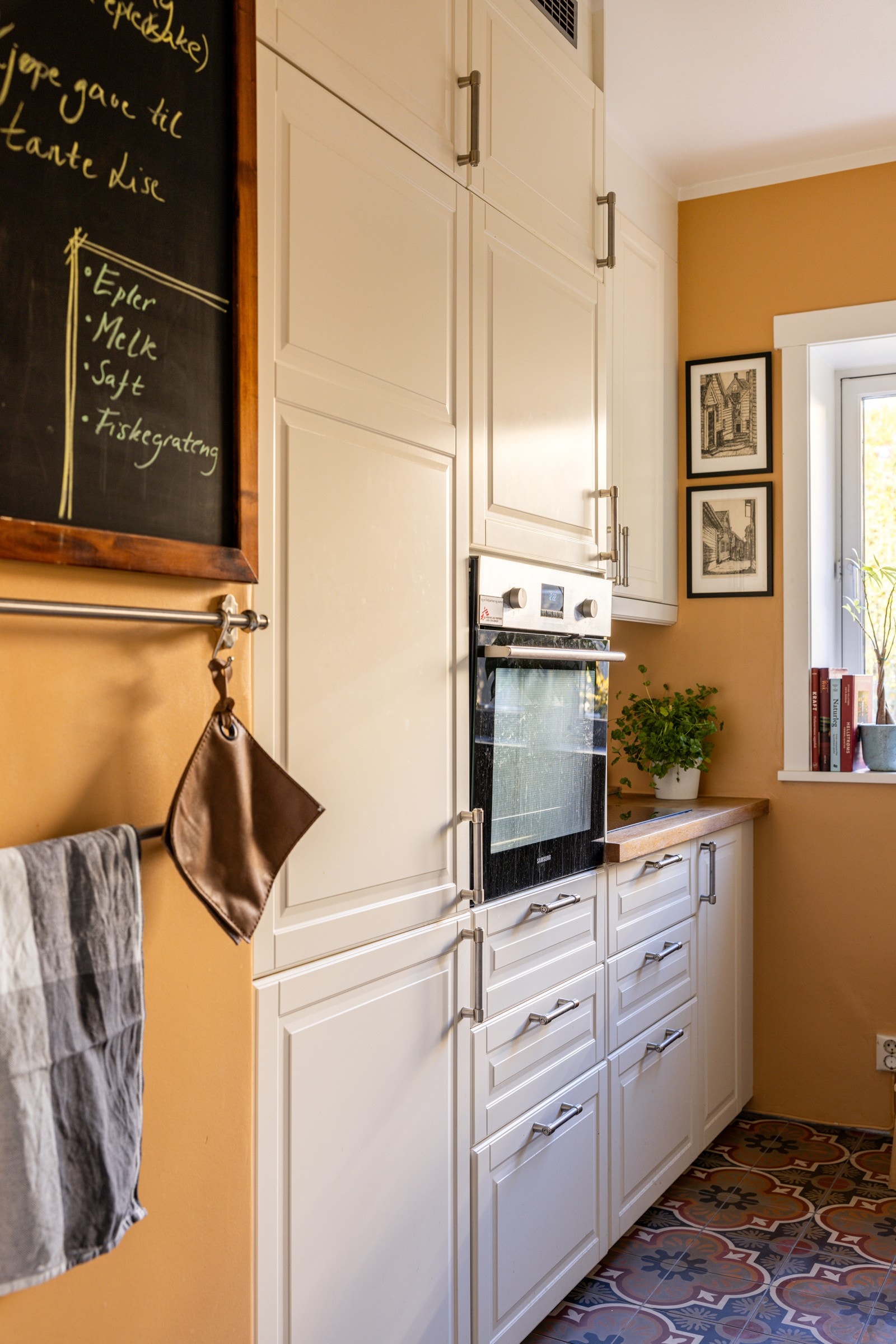 Her finner du også integrerte hvitevarer, inkludert en innebygd ovn, samt benkebelysning under overskapene som gir godt arbeidslys. Det store vinduet over kjøkkenbenken slipper inn rikelig med naturlig lys, noe som gjør rommet luftig og innbydende. Galleribilde