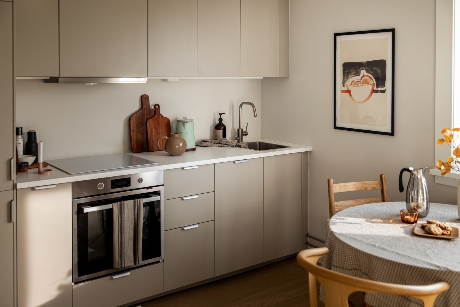 Kjøkkenet er utstyrt med integrerte hvitevarer, inkludert induksjonstopp, stekeovn, oppvaskmaskin og kjøle-/fryseskap. Det er også installert komfyrvakt og aquastop/lekkasjevarsler for ekstra sikkerhet. Galleribilde