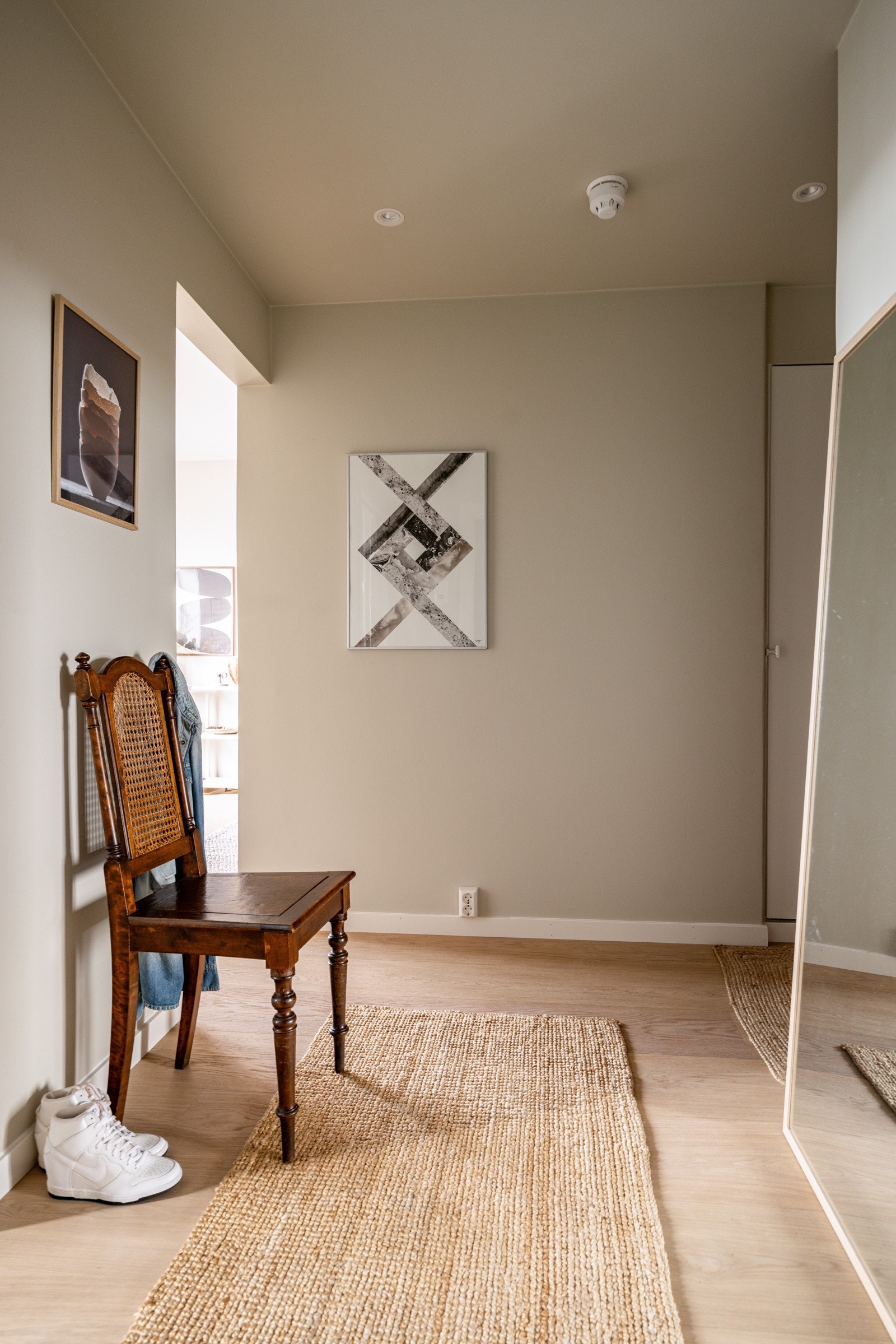 Entréen er utstyrt med downlights i himlingen, som gir jevn og behagelig belysning. Det veggintegrerte, plassbygde skapet på 1 kvm gir god oppbevaringsplass til yttertøy og sko, og holder rommet ryddig og organisert. Galleribilde