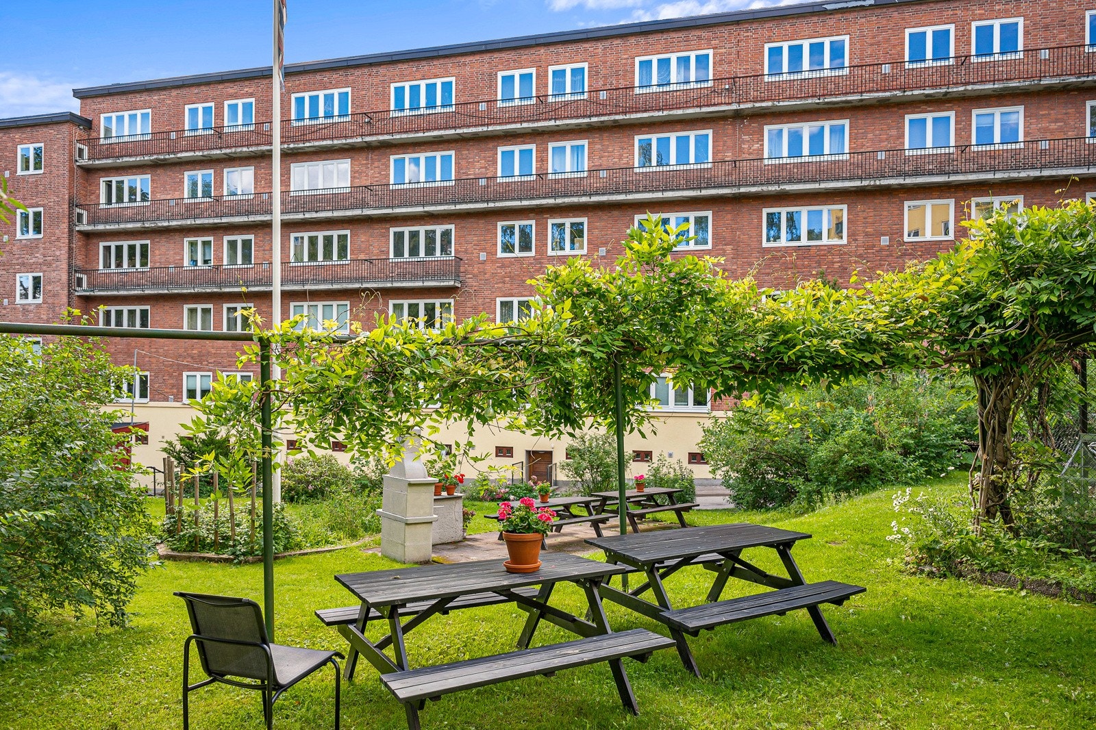 Uteområdet er pent opparbeidet med beplantning, sittebenk og asfalterte veier. Galleribilde