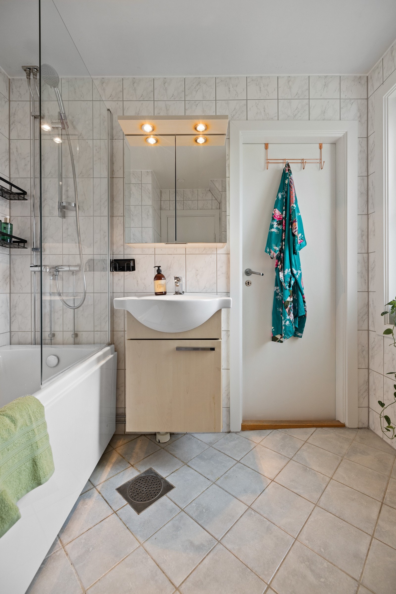 Badet fra 2009 har flislagte overflater, gulvvarme, et pent baderomsmøblement og badekar Galleribilde