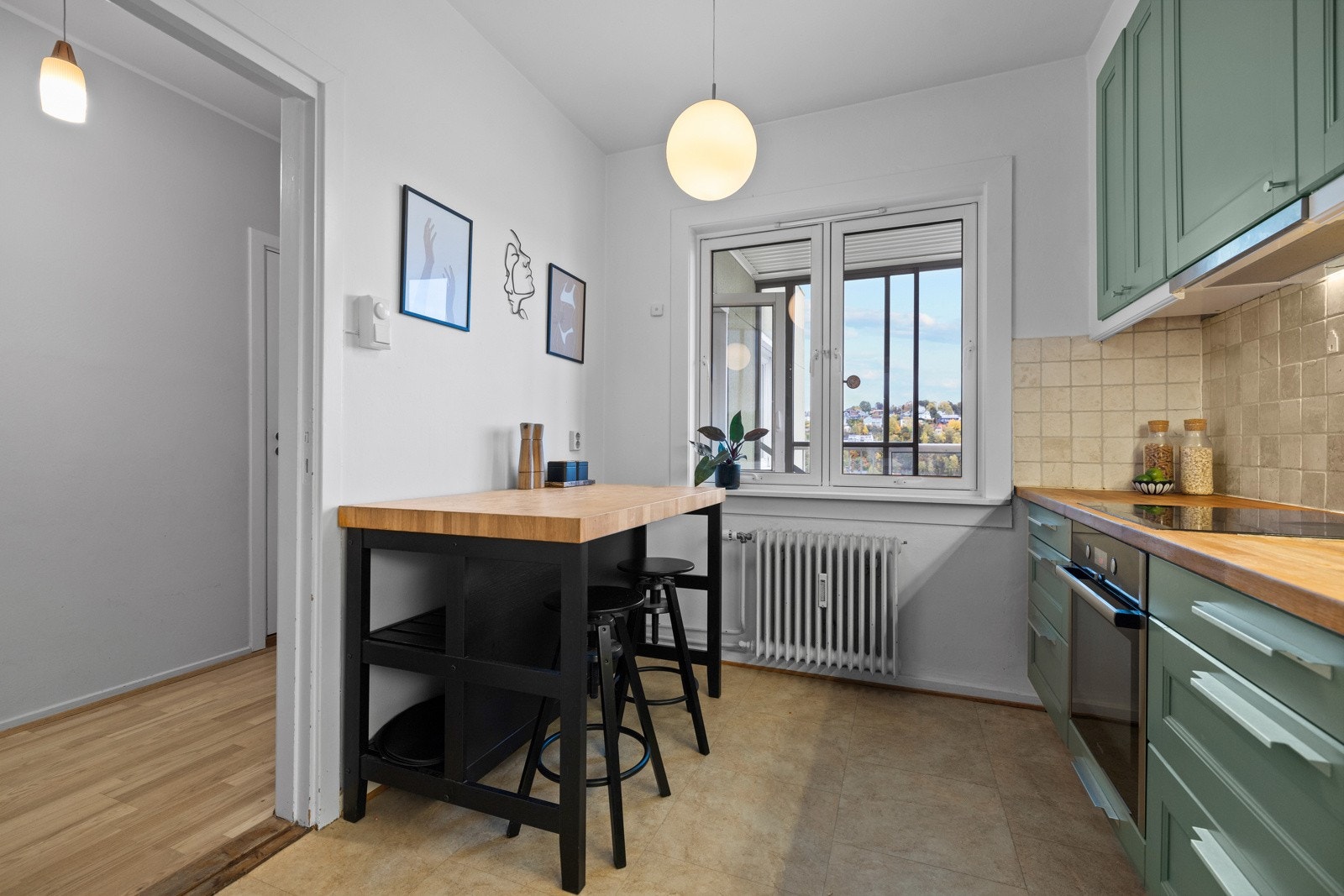 Et vindu vender ut mot innglasset balkong og gir muligheter for sitteplass ved barløsning eller et lite spisebord Galleribilde