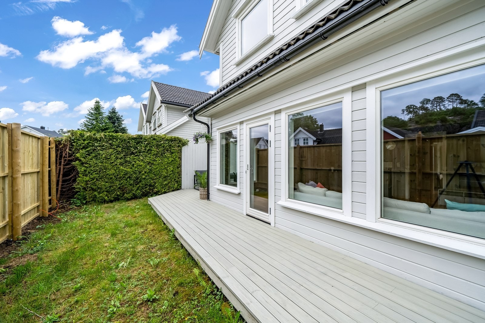 Terrassegang i front av boligen som fører til en avskjermet terrasse på siden. Galleribilde