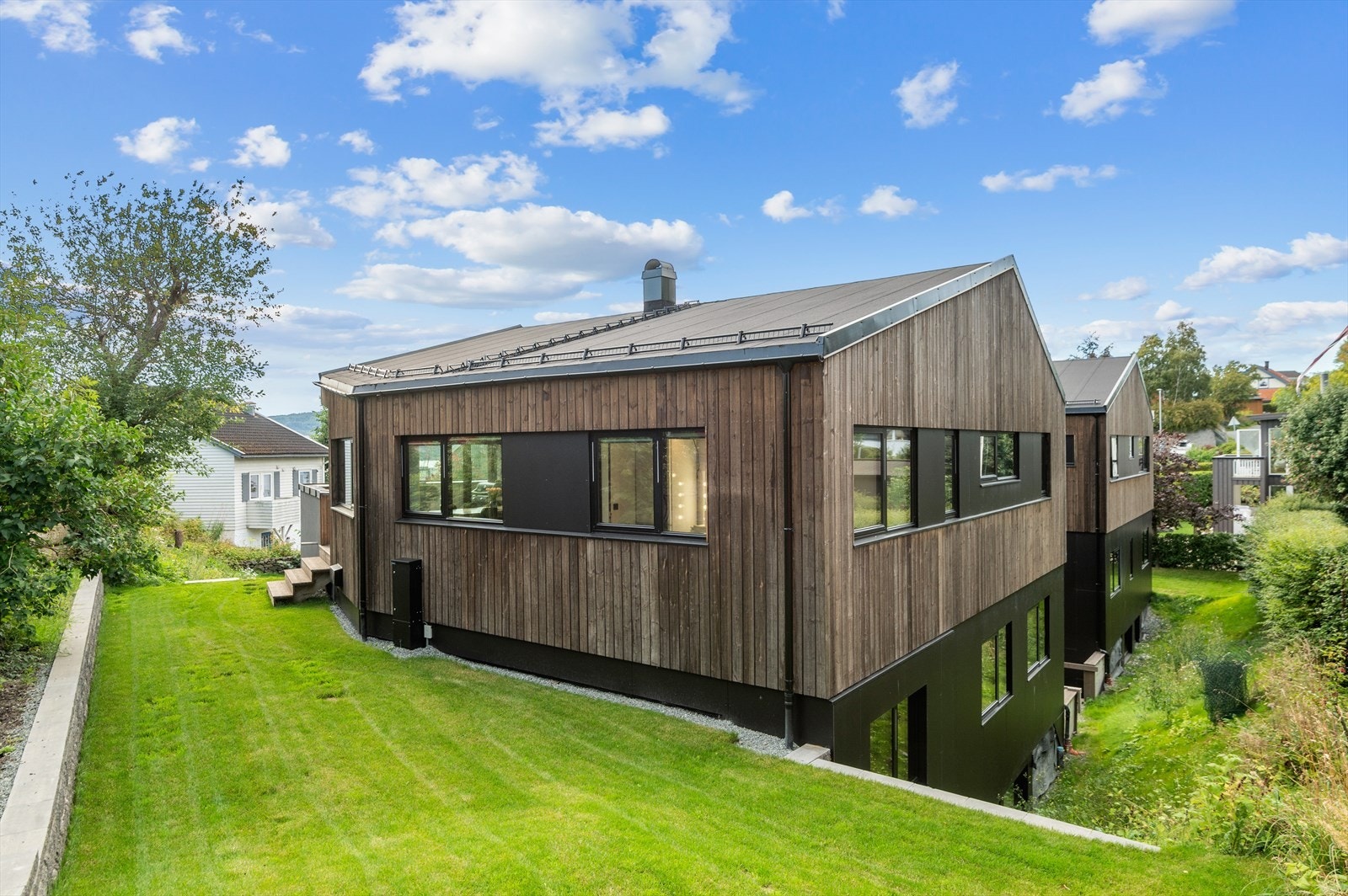 Her får du en lekker og tilbaketrukket hage med trapp ned til gårdsplassen og takterrassen Galleribilde