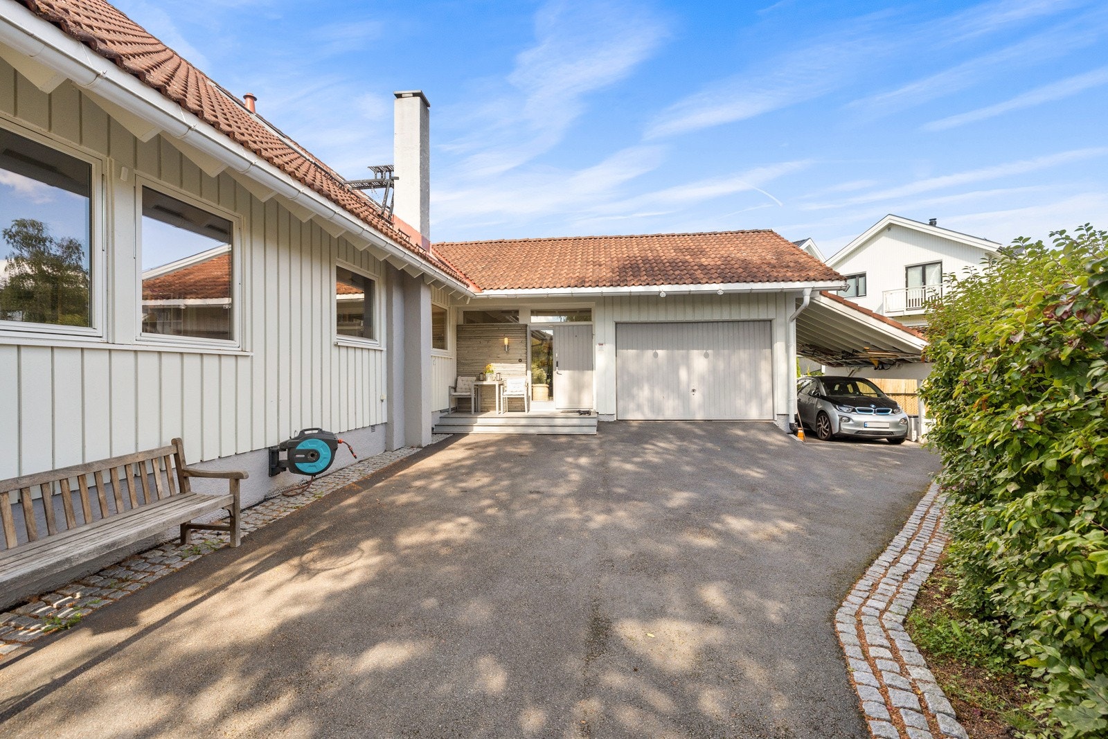 Garasje og carport, samt flere parkeringsmuligheter på tomten. Elbillader ble montert i 2020. Galleribilde