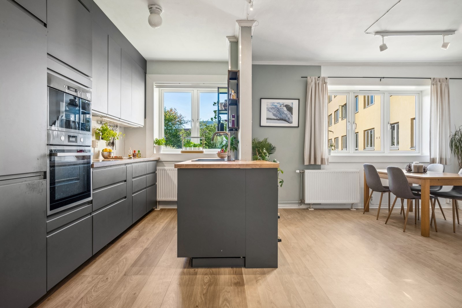 Vegg og kjøkkenøy gir et naturlig skille mellom stue og kjøkken men bevarer den åpne romfølelsen. Galleribilde