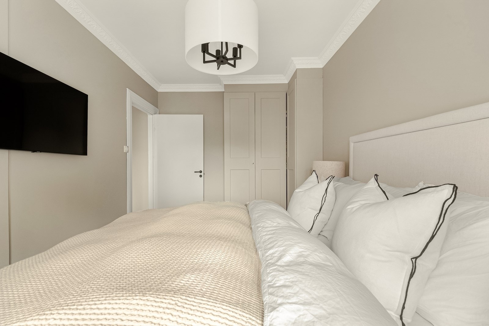 Plassbygd garderobeskap som er malt i samme farge som veggene. Galleribilde