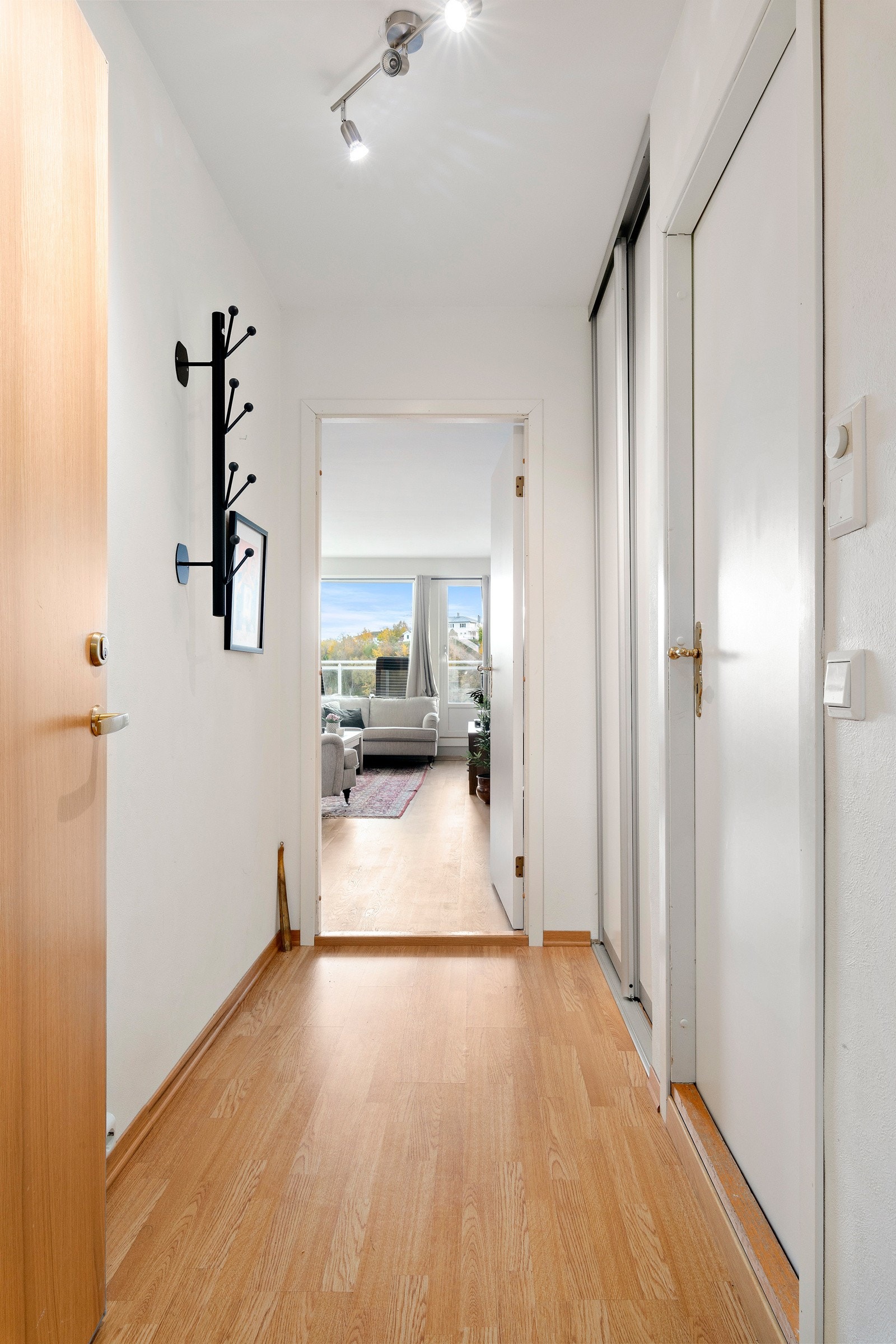 Vi kommer inn i en gang med skyvedørsgarderobe hvor man kan henge fra seg yttertøyet. Galleribilde